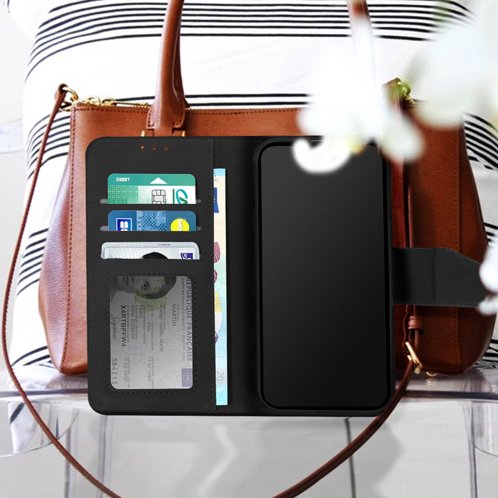 Un étui de téléphone ouvert, affichant des cartes et un téléphone. Un sac et une personne sont en arrière-plan.