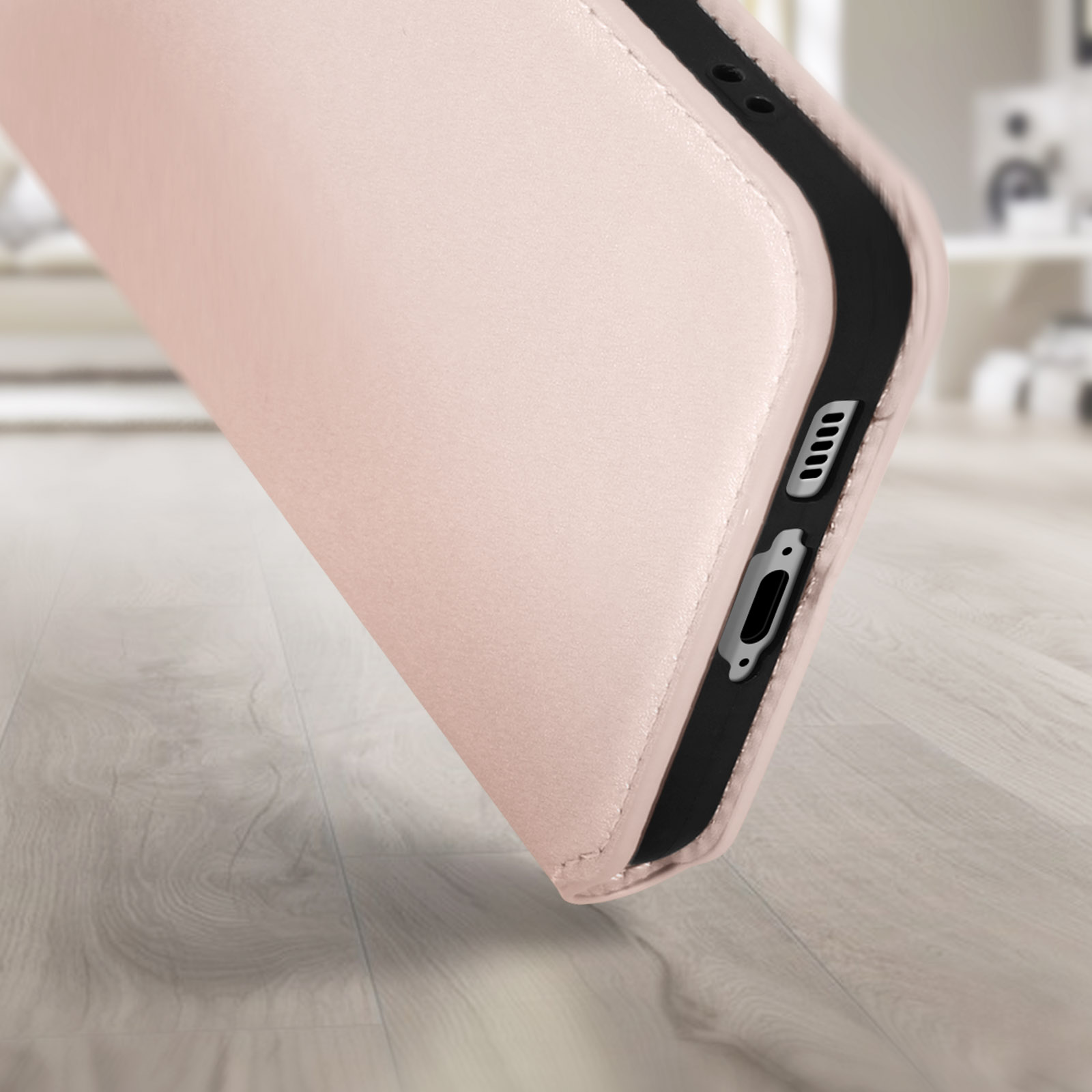 Gros plan sur un étui de téléphone, montrant les ports et les boutons. La couleur est rose clair.