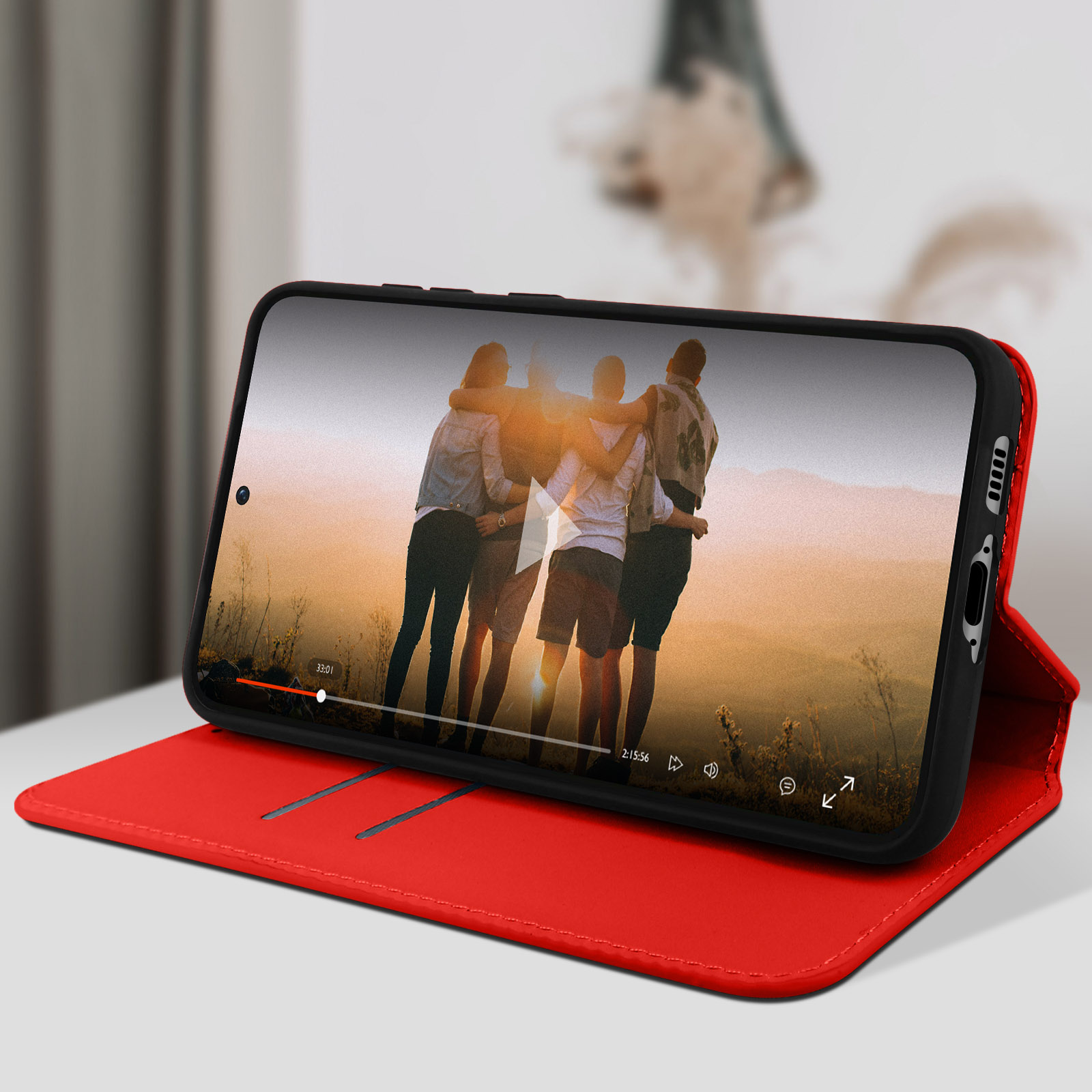 Un téléphone affichant une vidéo avec des personnes sur un étui rouge.