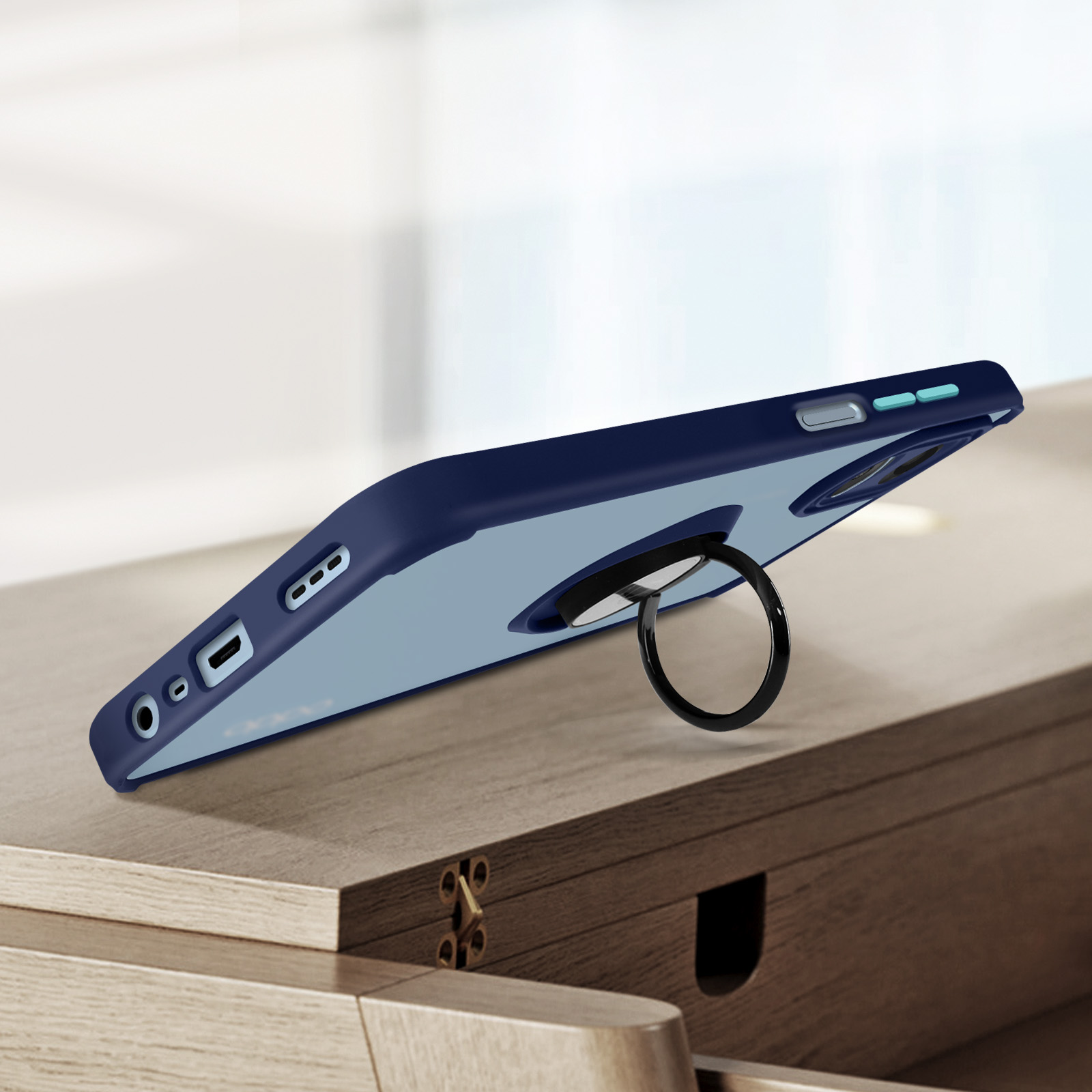 Custodia blu per telefono con anello di supporto su superficie in legno. Porte visibili.