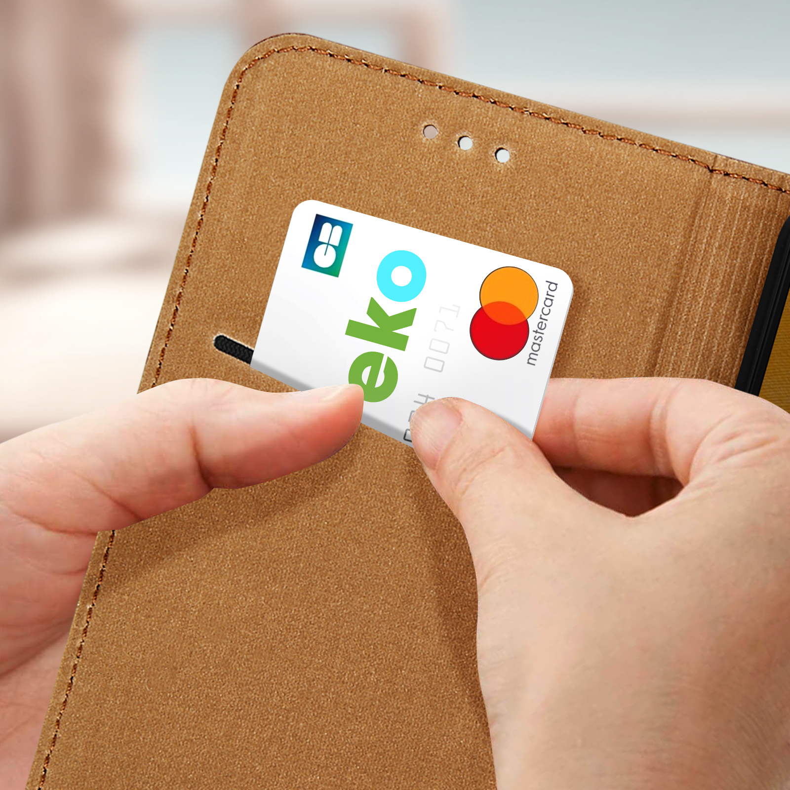 Mani inseriscono una carta di credito in una custodia marrone per telefono.