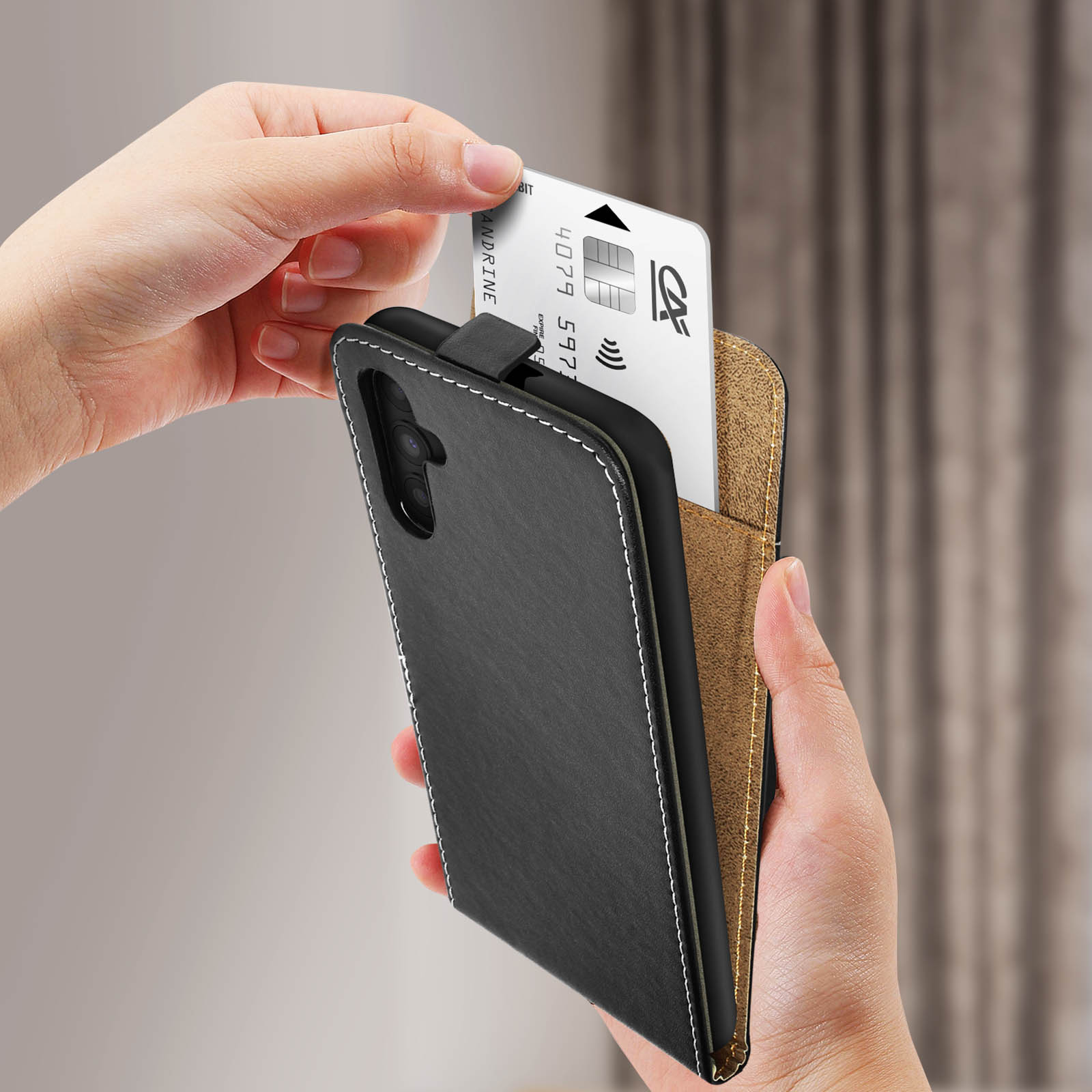 Una mano che tiene un telefono in una custodia a portafoglio. Si sta inserendo una carta di credito.