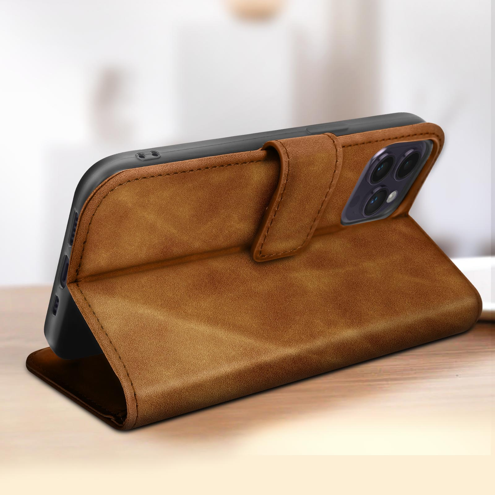 Braune Leder-Handyhülle, offen auf einem Holztisch. Das Telefon ist darin.