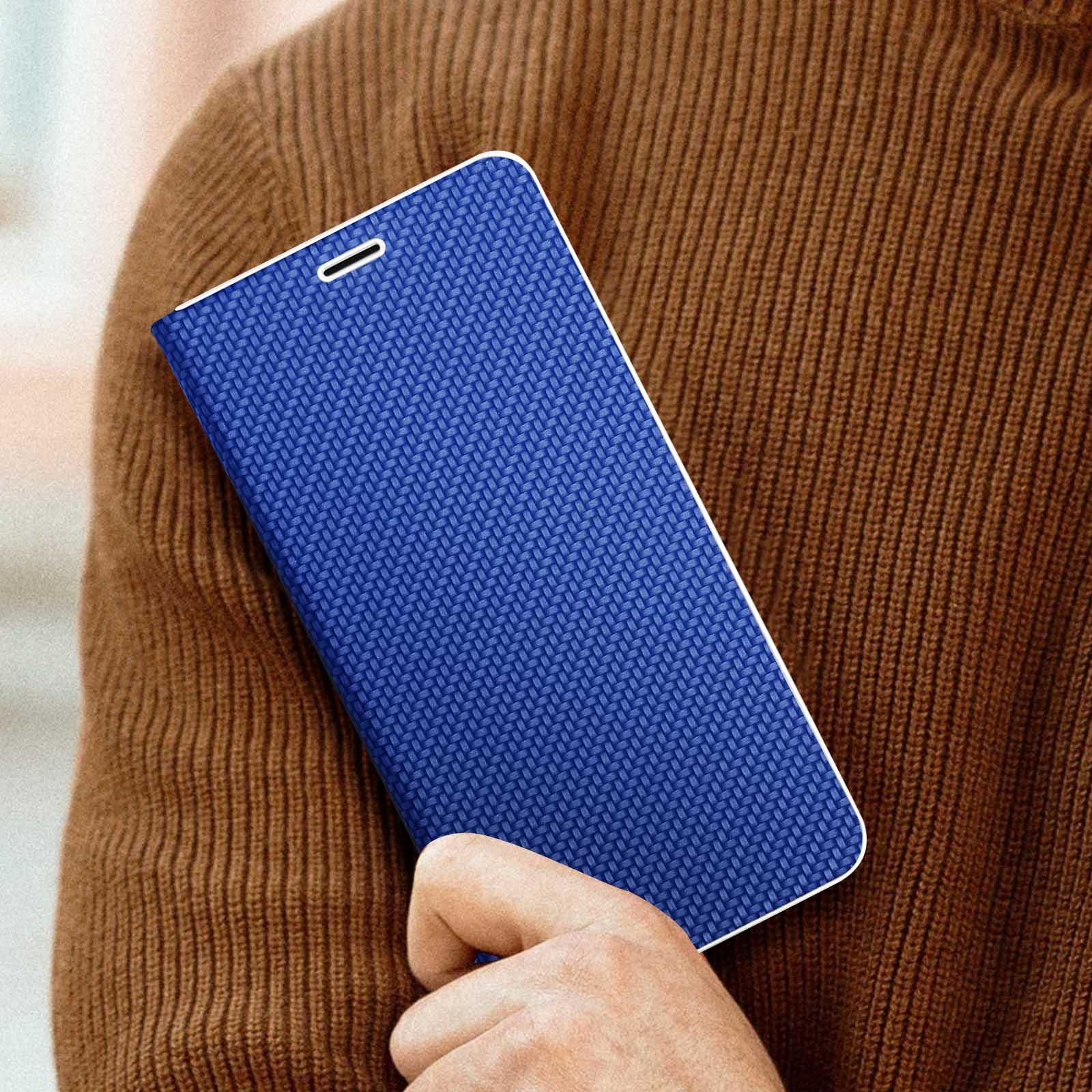Blaue Handyhülle mit strukturiertem Muster, in der Hand gehalten. Im Hintergrund ein brauner Pullover.