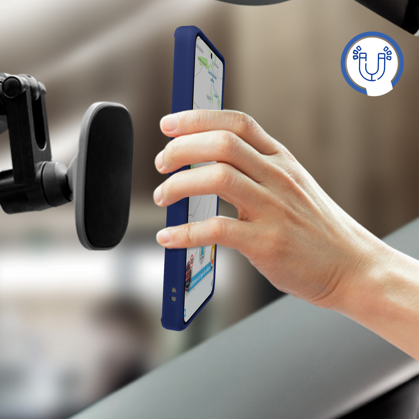 Un téléphone dans un étui bleu monté sur le tableau de bord d'une voiture, près d'un support de téléphone magnétique.
