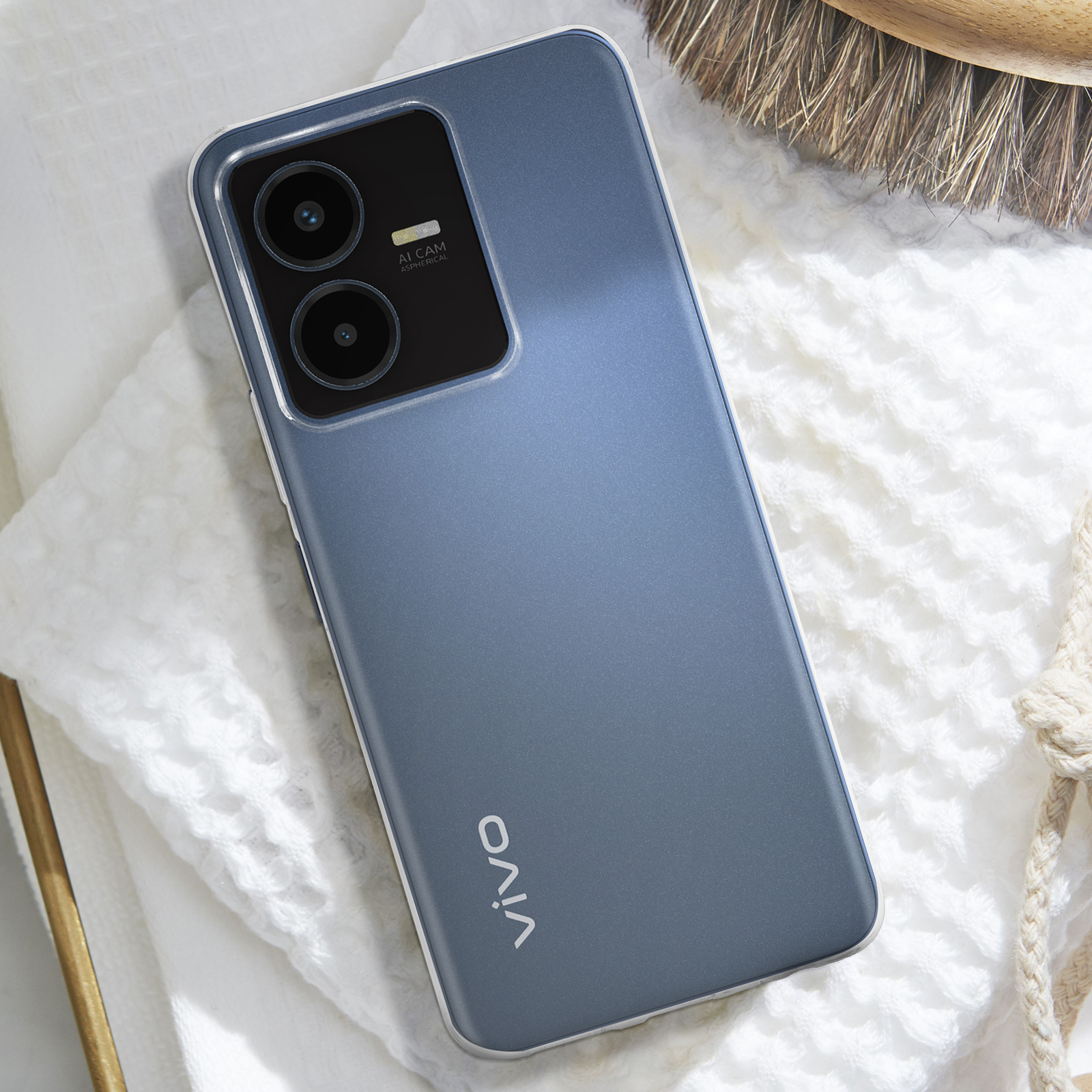 Un telefono su un asciugamano bianco. Il telefono è blu, con una custodia. Lo sfondo è sfocato.