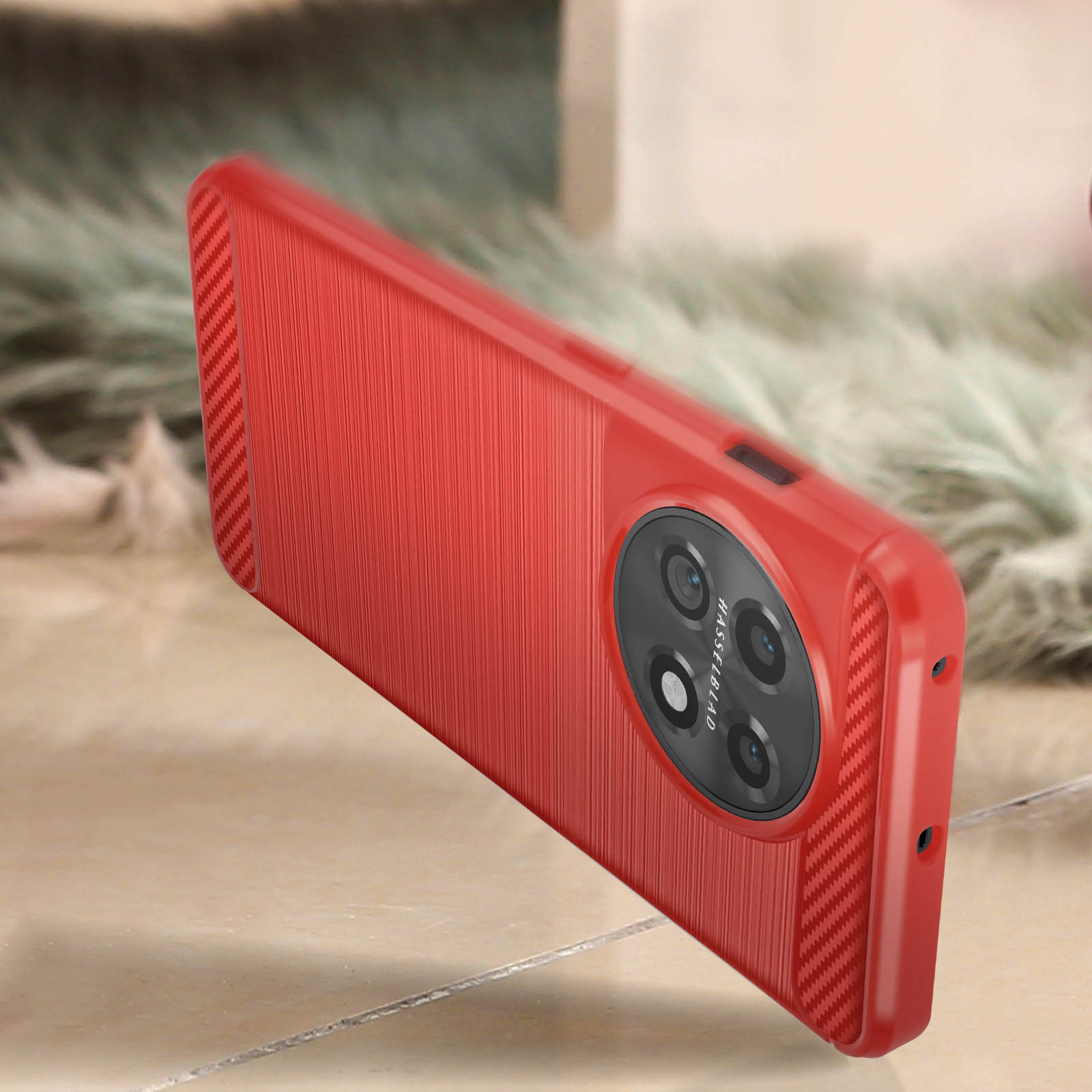 Custodia rossa con fotocamera nera. La custodia ha una superficie strutturata. Lo sfondo è sfocato.
