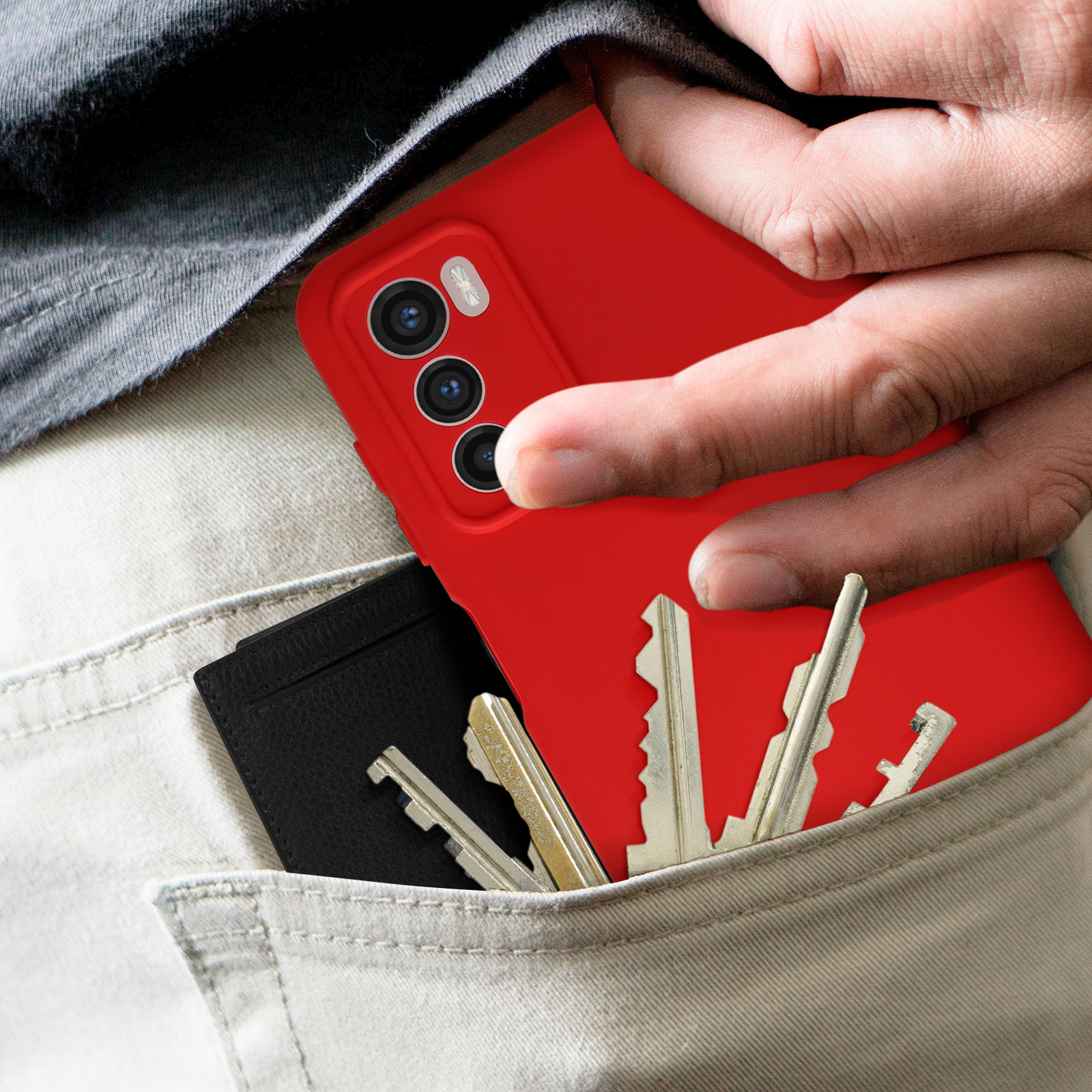 Telefono rosso in tasca con chiavi e portacarte. Pantaloni grigi.