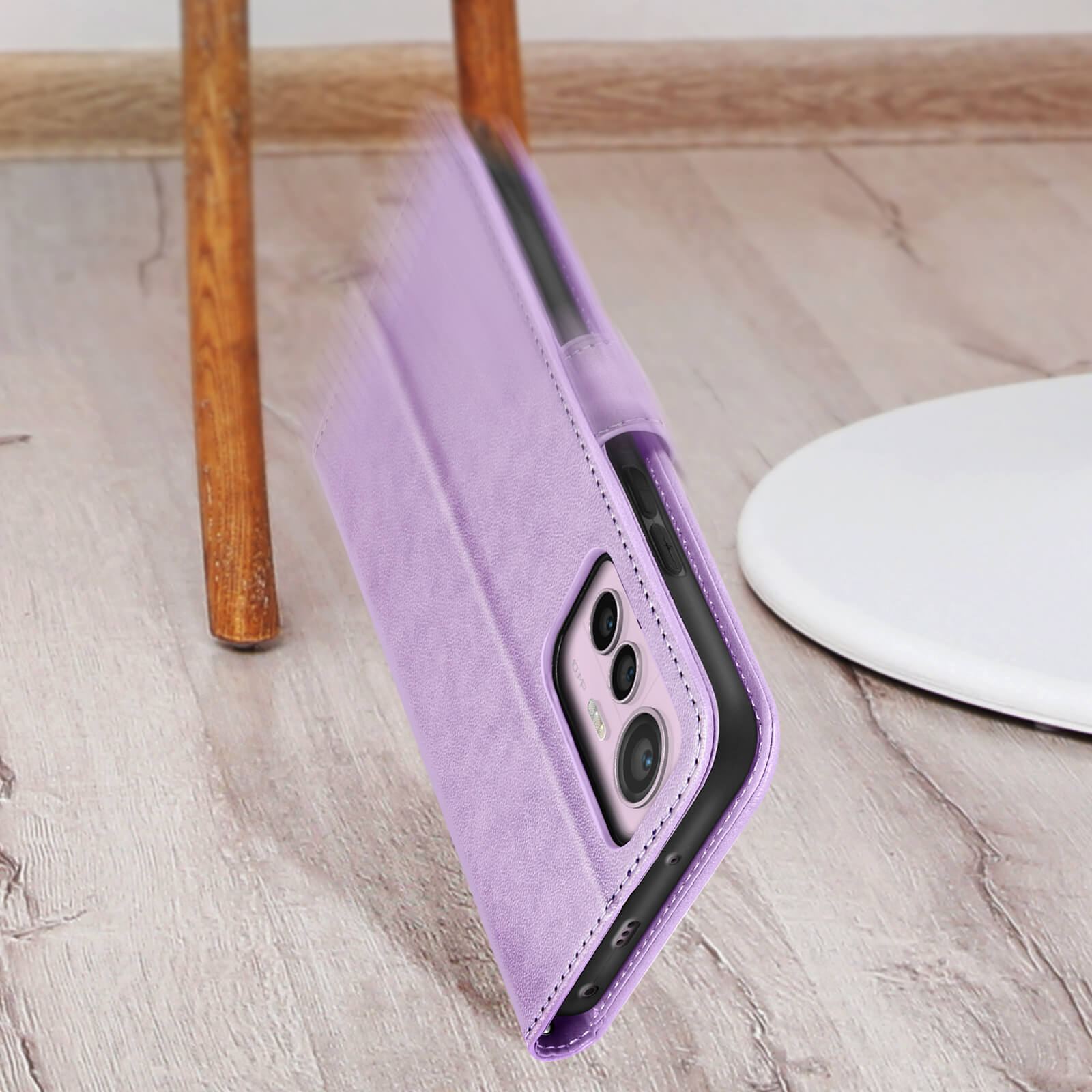 Una custodia viola per telefono sta cadendo. Il telefono è visibile all'interno. Sfondo con pavimento in legno.