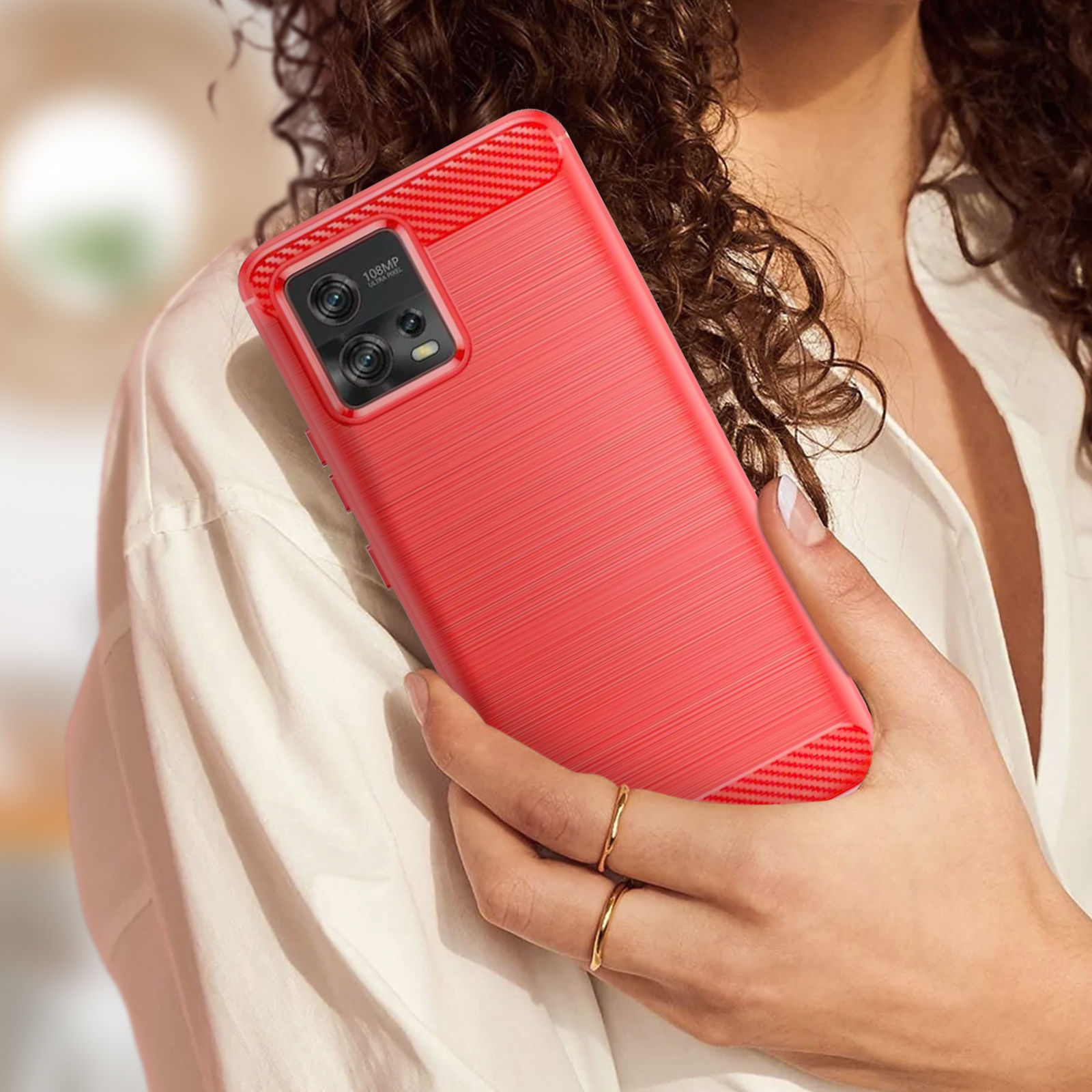 Donna che tiene una custodia rossa con un telefono dentro.