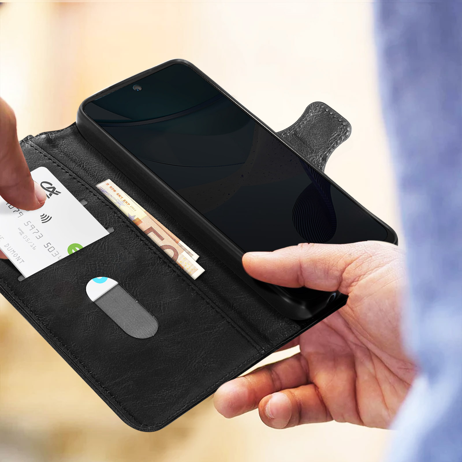 Mani che aprono una custodia nera per telefono, rivelando telefono, carta e banconota.