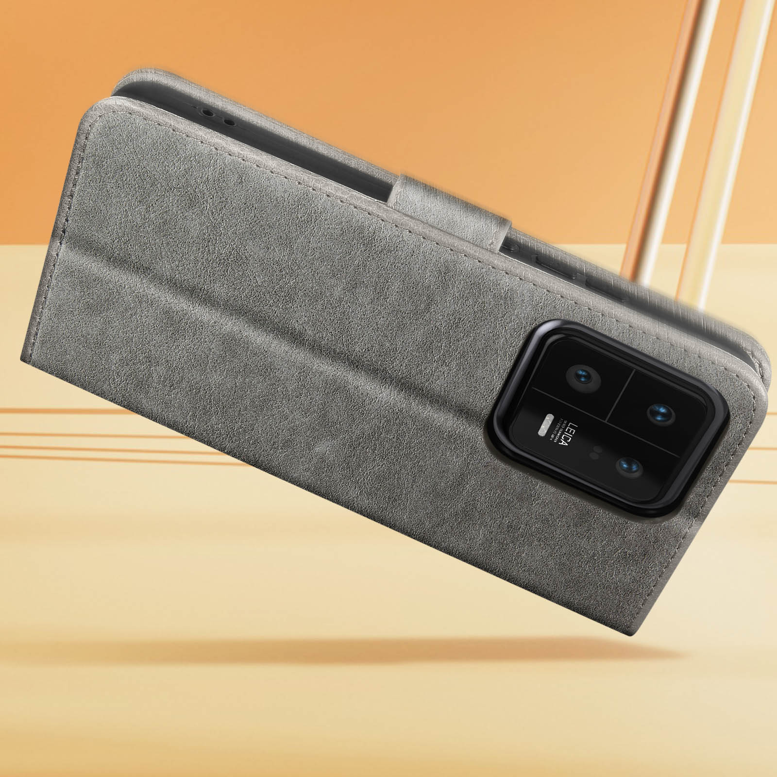 Un étui de téléphone gris, ouvert, avec un téléphone à l'intérieur, sur une surface jaune.