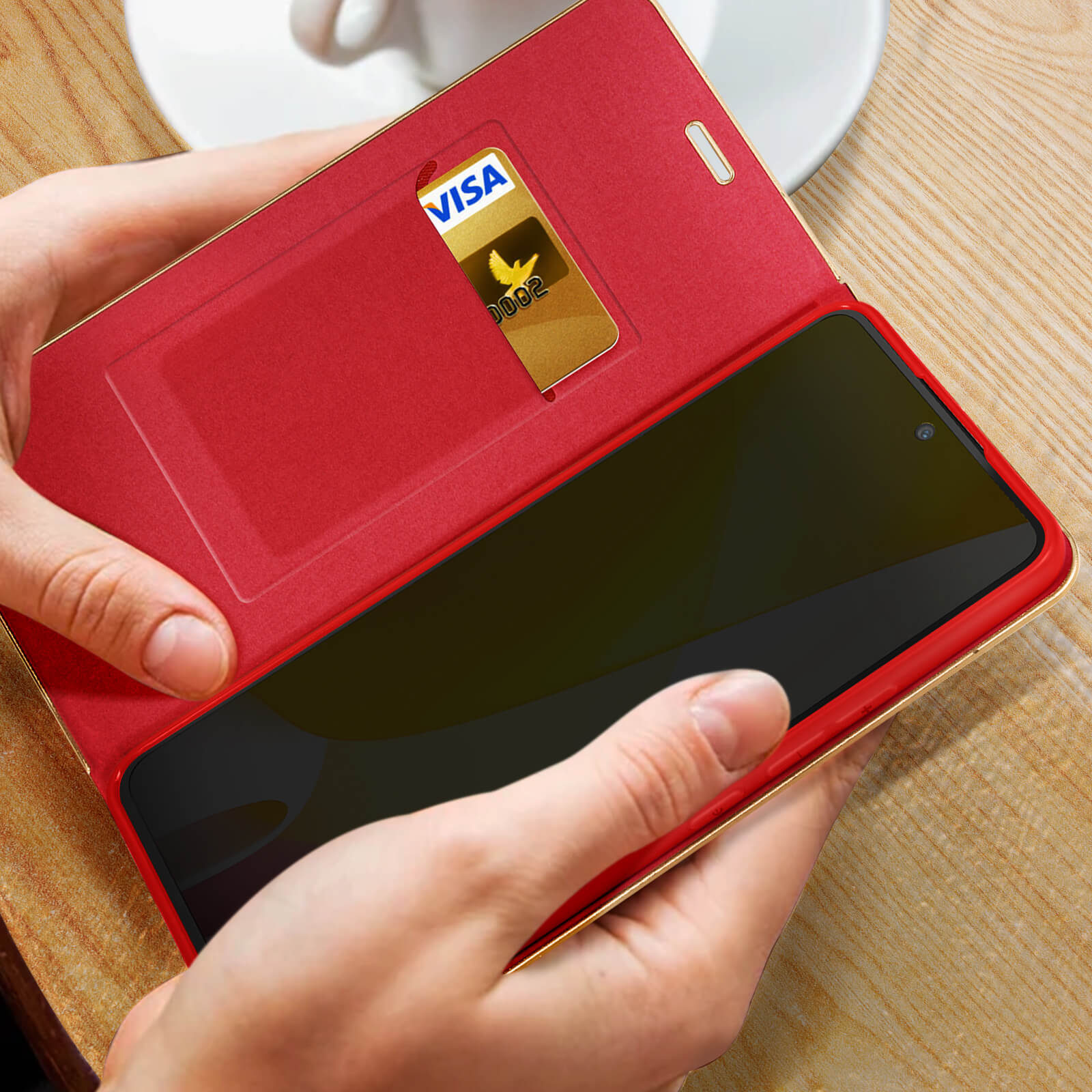 Mani che tengono una custodia per telefono rossa con una carta d'oro. Lo schermo del telefono è visibile.