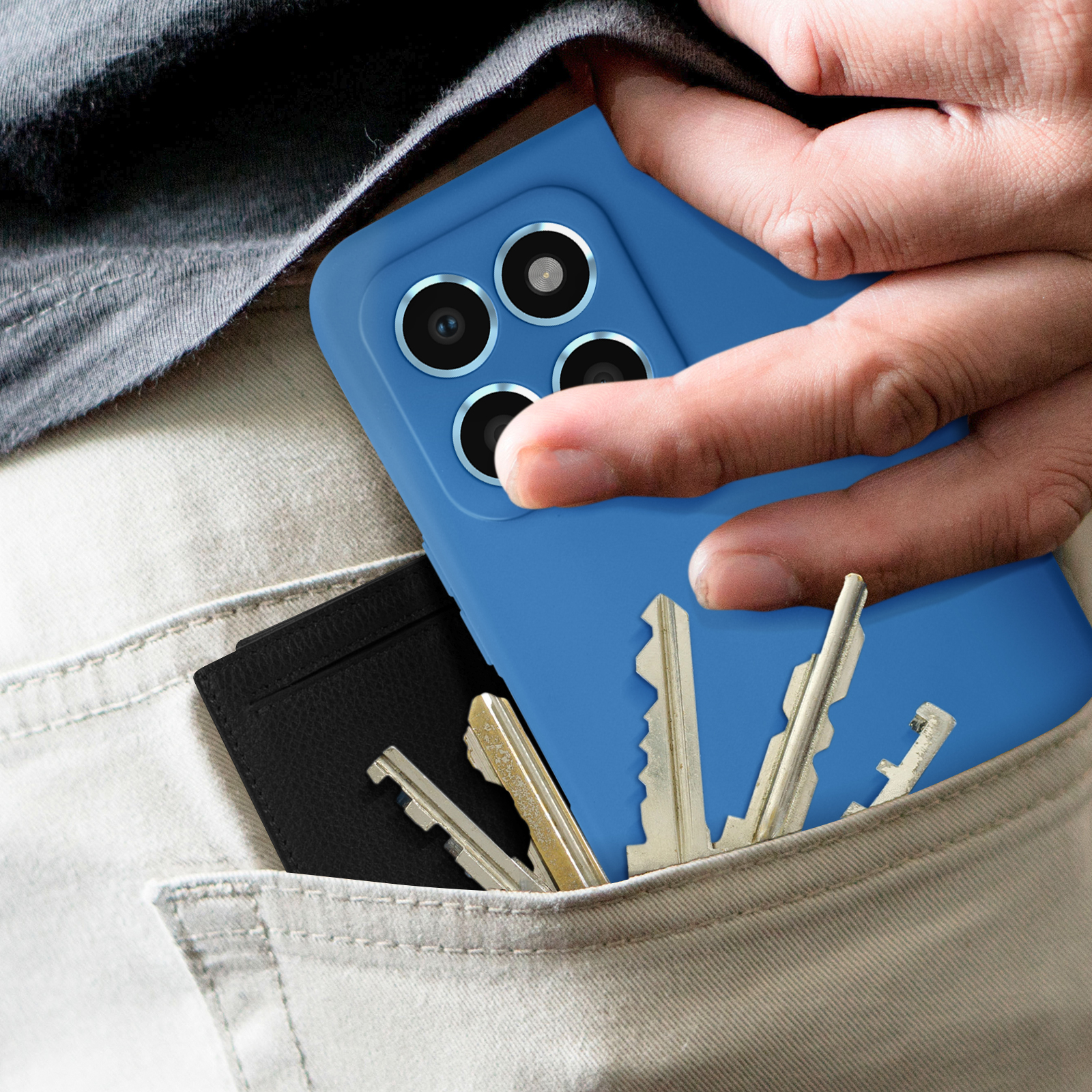 Hand in zak met blauwe telefoonhoes, sleutels en zwarte kaarthouder.