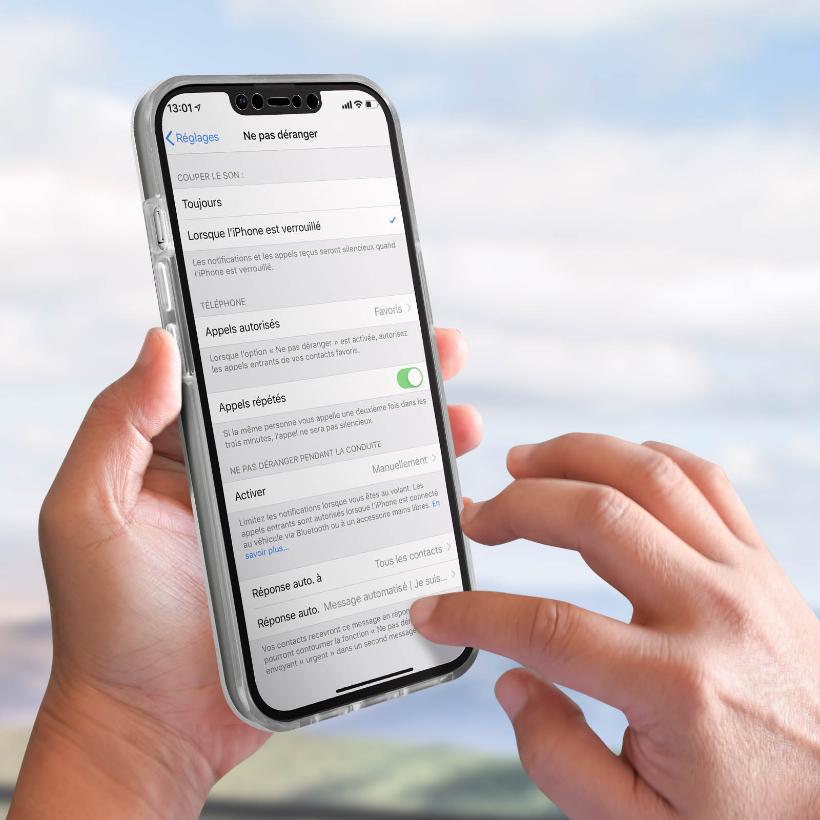 Una mano che tiene un telefono con una custodia trasparente, che mostra il menu delle impostazioni. Lo schermo è acceso.