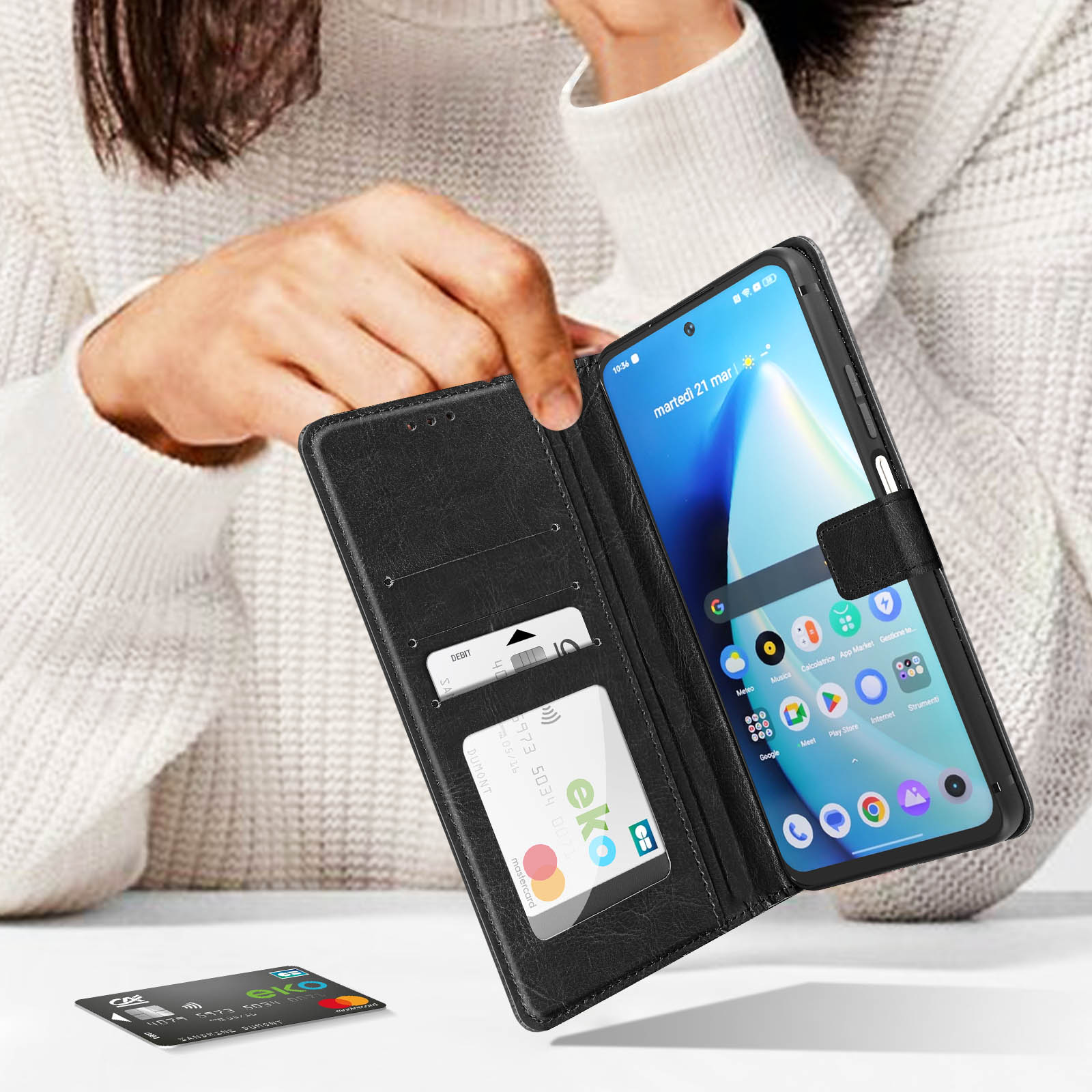 Eine Person hält eine schwarze Handyhülle geöffnet und zeigt ein Telefon und Karten.