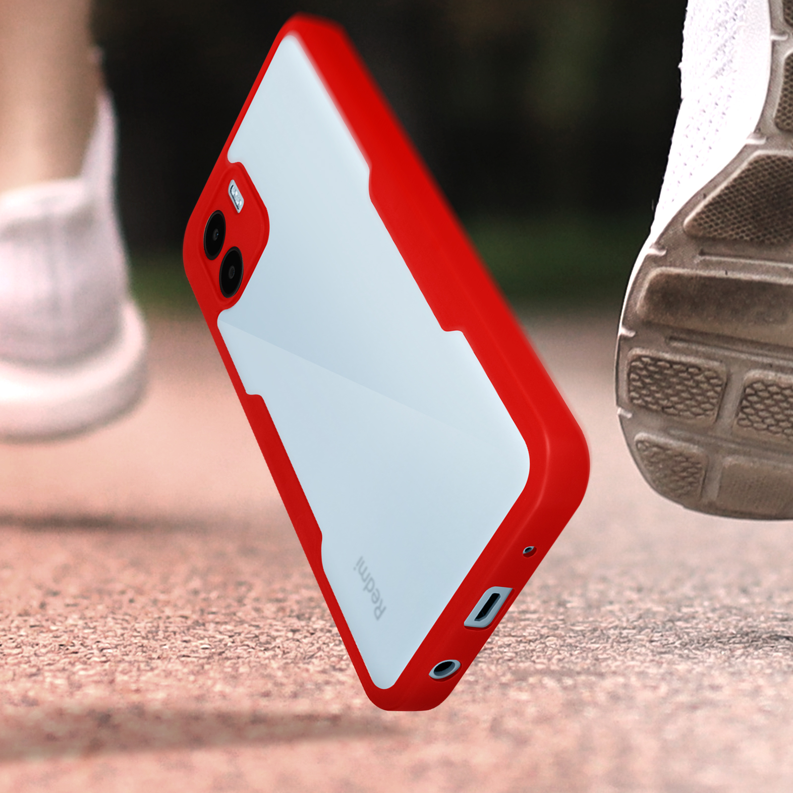 Custodia rossa per telefono su una superficie ruvida, con uno sfondo sfocato di qualcuno che corre. La custodia è di lato.