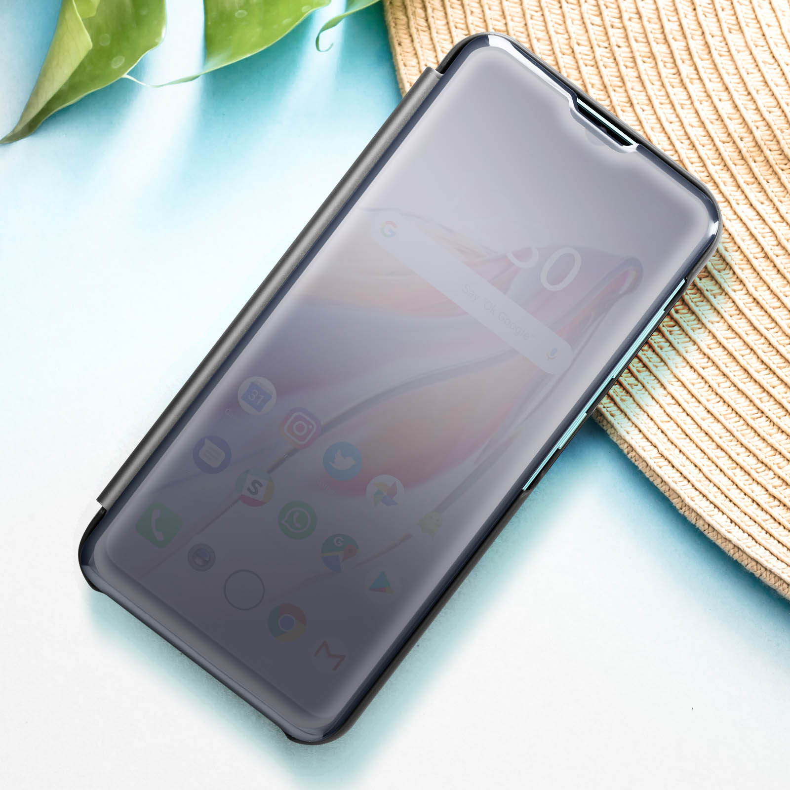 Telefono con protezione schermo in una custodia nera. Lo sfondo è sfocato con icone visibili.