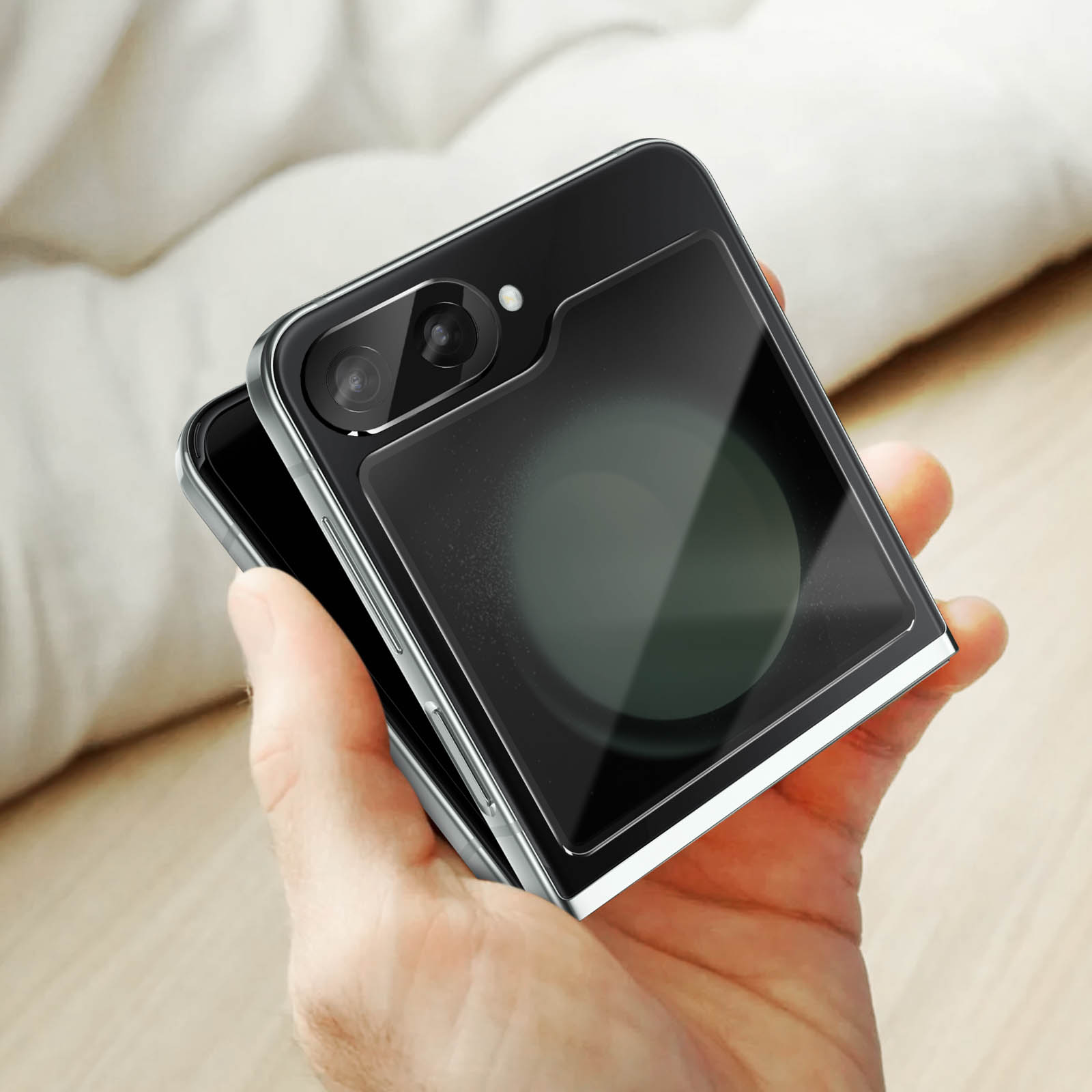 Una persona che tiene un telefono piegato con una protezione per lo schermo. La fotocamera del telefono è visibile.