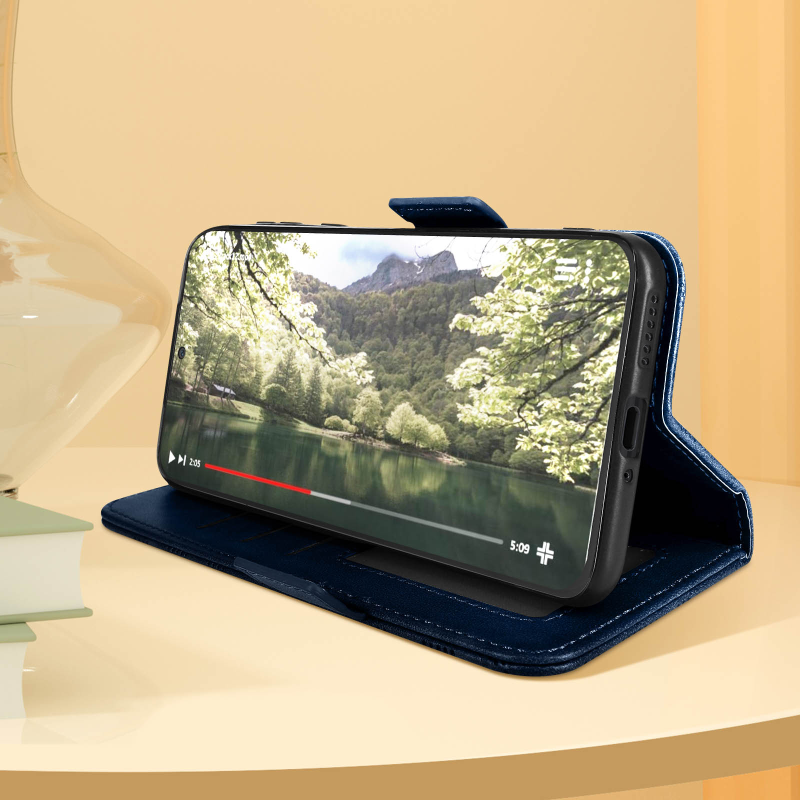 Custodia del telefono aperta che mostra un telefono che riproduce un video. Un lago panoramico è in mostra.