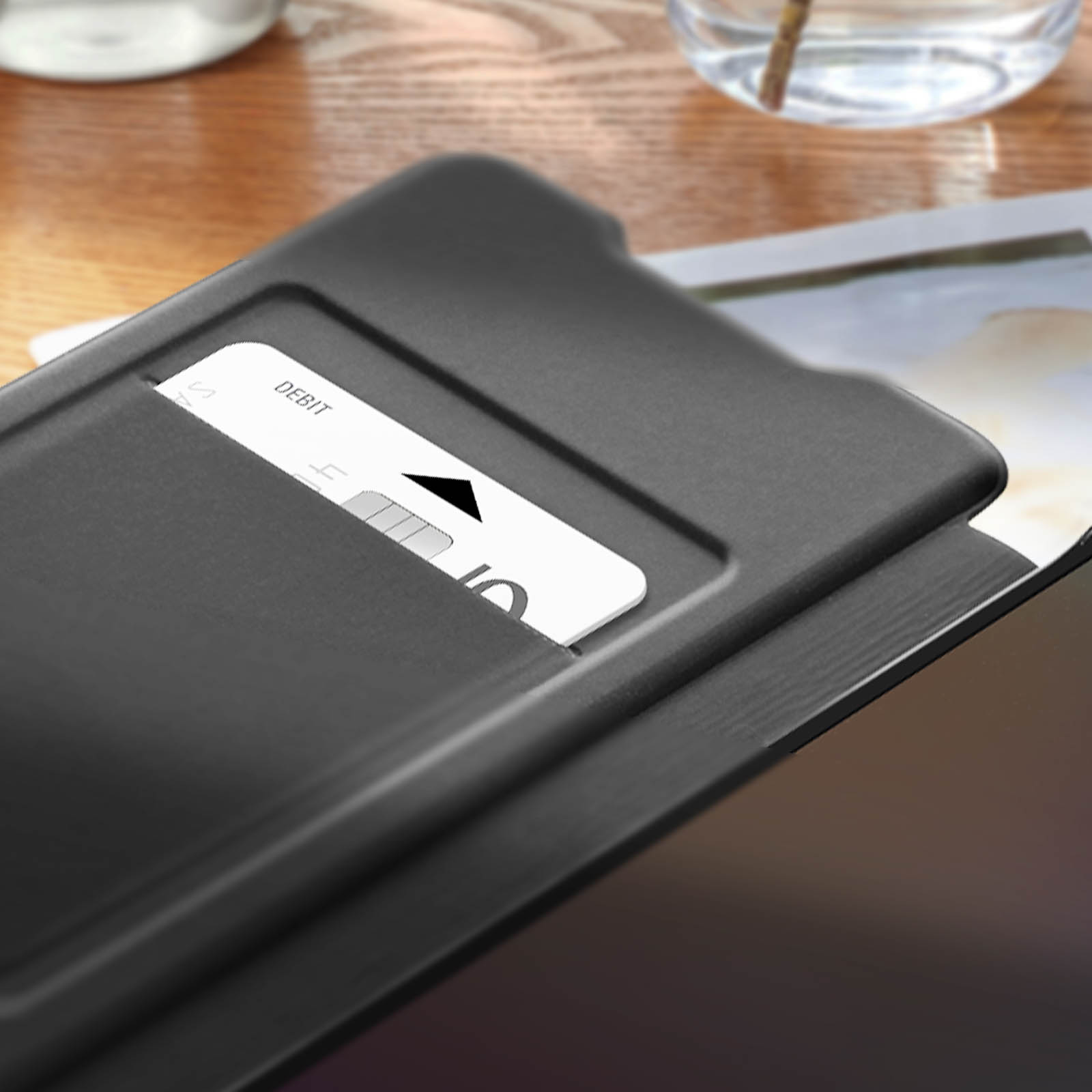 Schwarze Tablethülle mit Karte in der Tasche. Das Tablet ist teilweise sichtbar. Der Hintergrund ist unscharf.