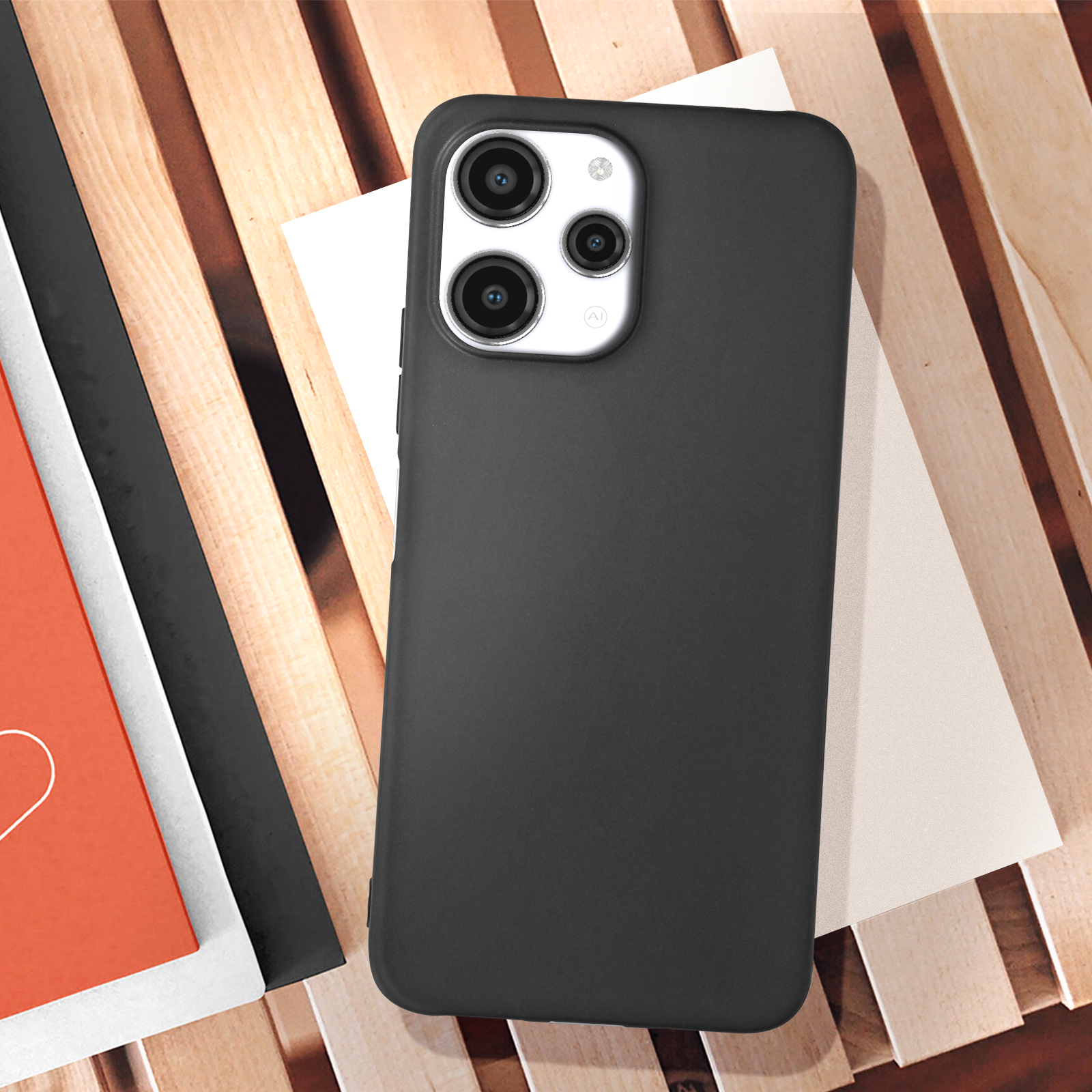 Custodia per telefono nera su una superficie di legno con libri. Il telefono ha più fotocamere. Lo sfondo è sfocato.
