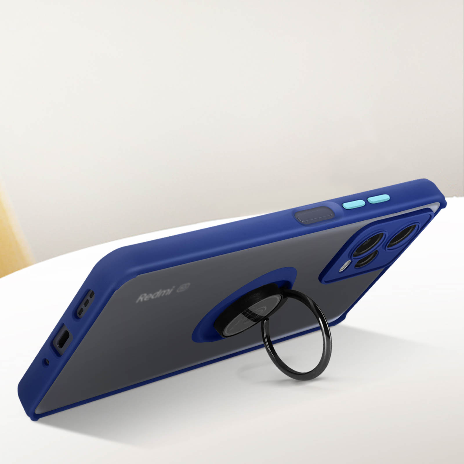 Custodia blu per telefono con anello, appoggiata su un tavolo. Il telefono è grigio scuro.