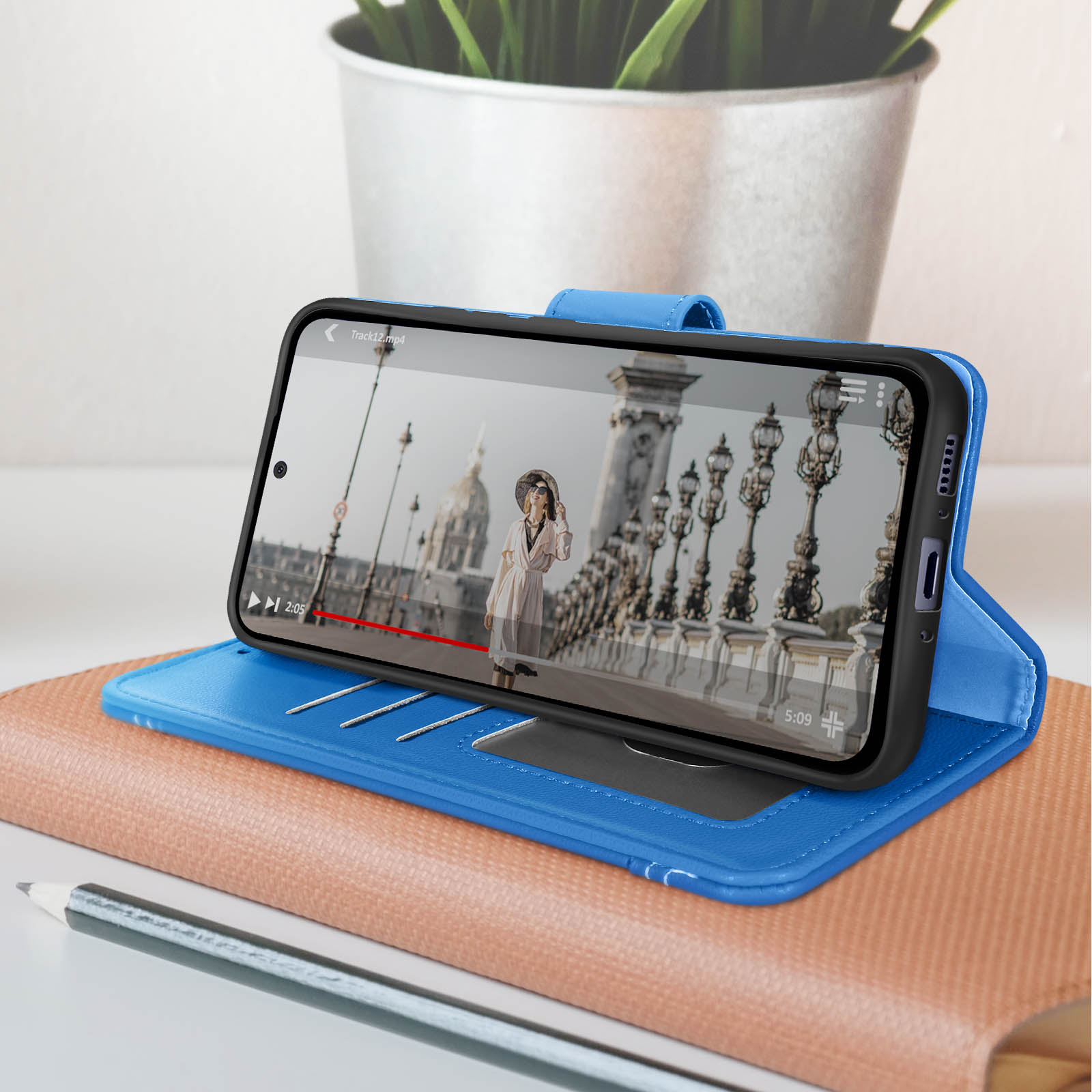 Una custodia blu per telefono con un telefono all'interno, che mostra un video su un ponte.