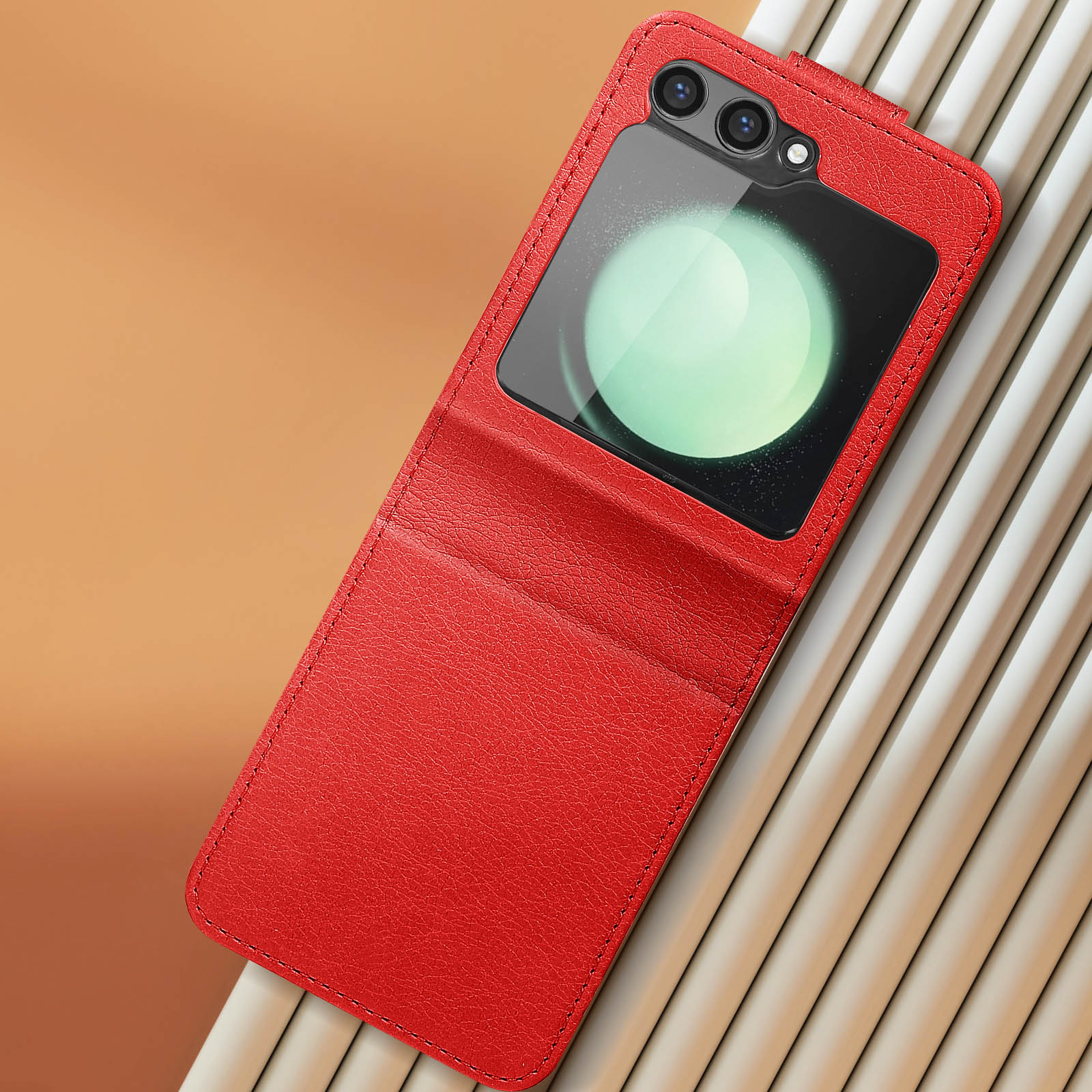 Funda de teléfono roja con pantalla. El fondo es una superficie naranja con líneas blancas.
