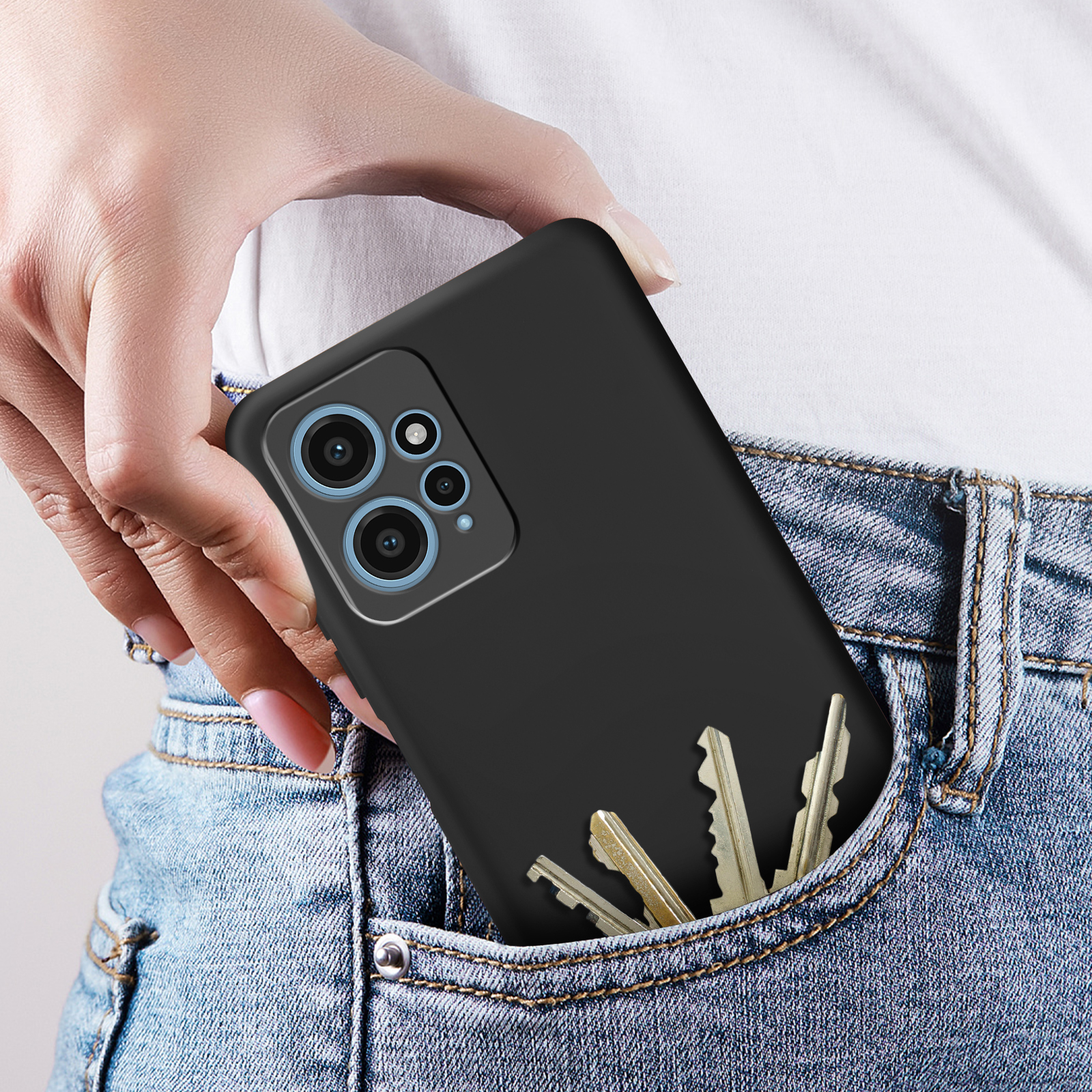 Un telefono in una custodia nera in una tasca di jeans. Chiavi visibili. La persona indossa jeans.