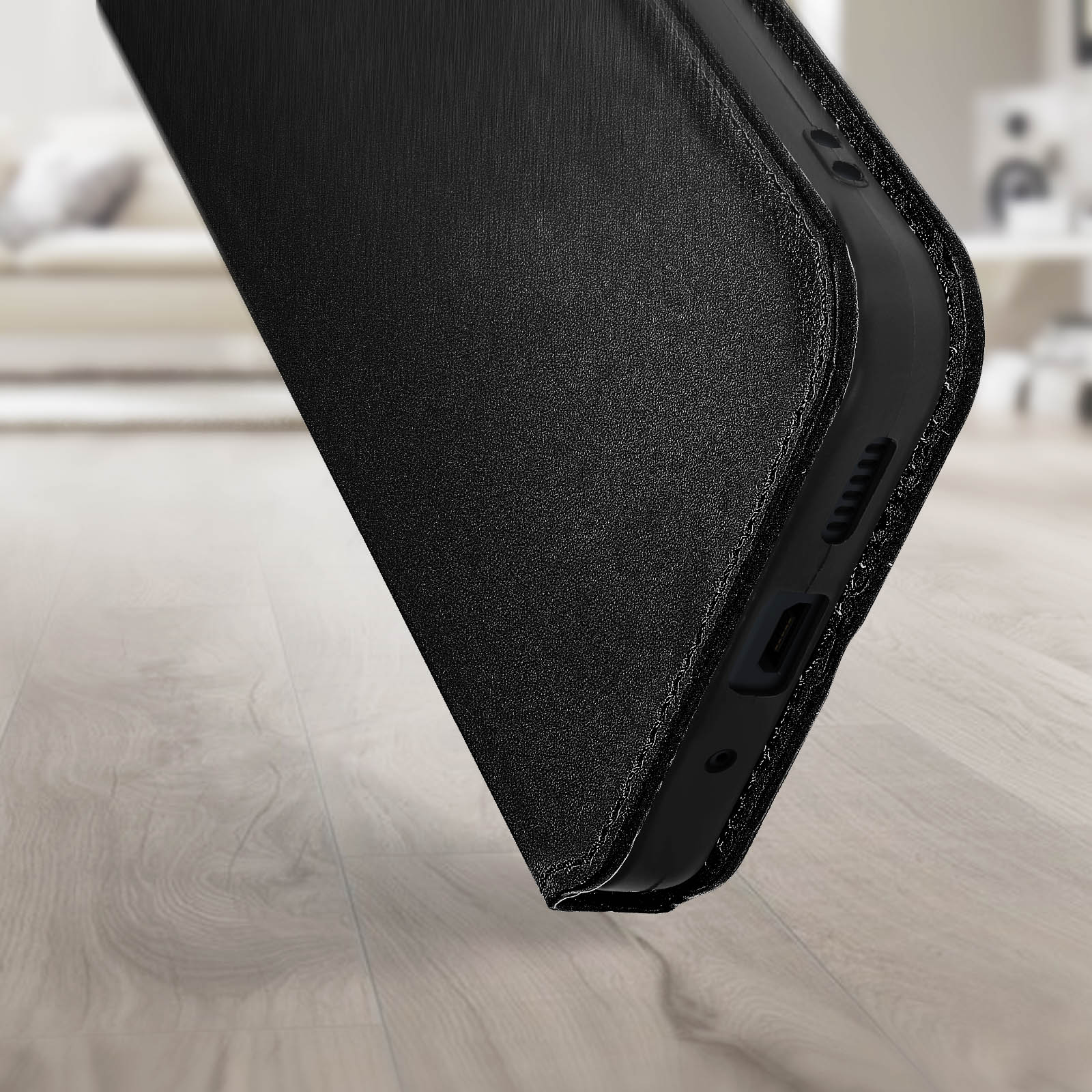 Custodia per telefono con superficie strutturata, in primo piano. Appoggiata su una superficie di legno.