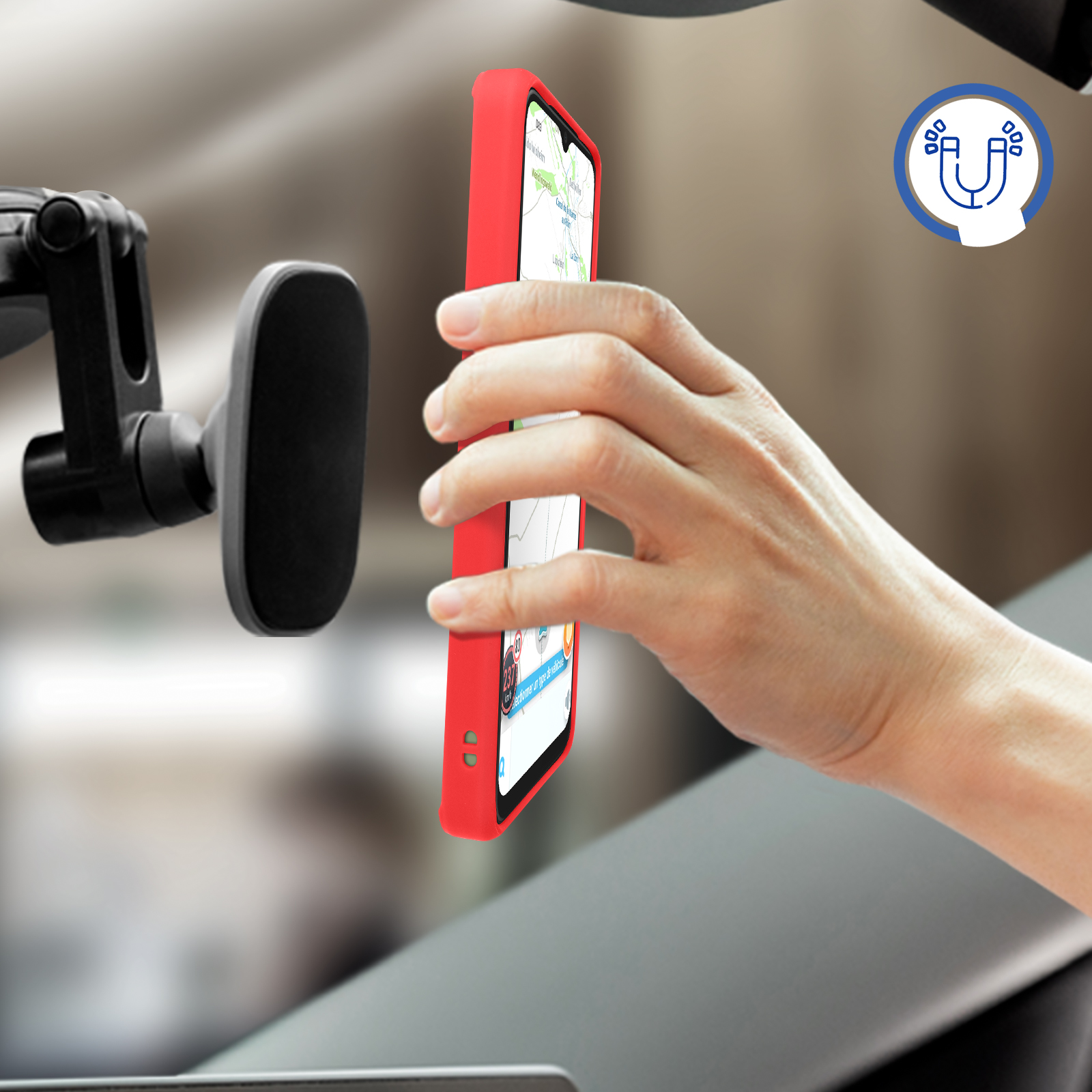 Telefono rosso in auto. Mano che lo tiene vicino a un supporto magnetico. Il telefono mostra una mappa.