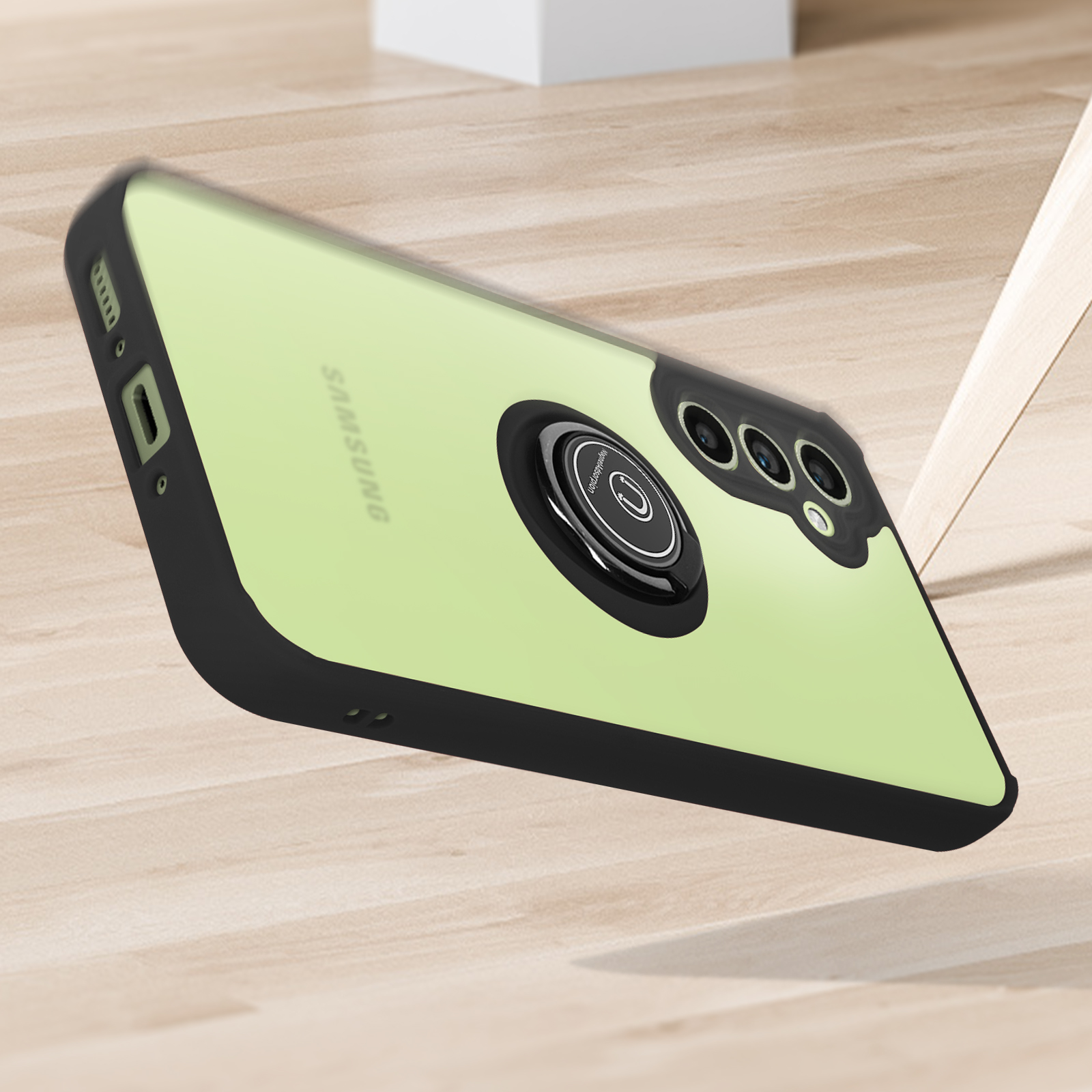 Viene mostrata una custodia per telefono con anello di supporto. La custodia è nera. Il telefono è verde. Lo sfondo è in legno.