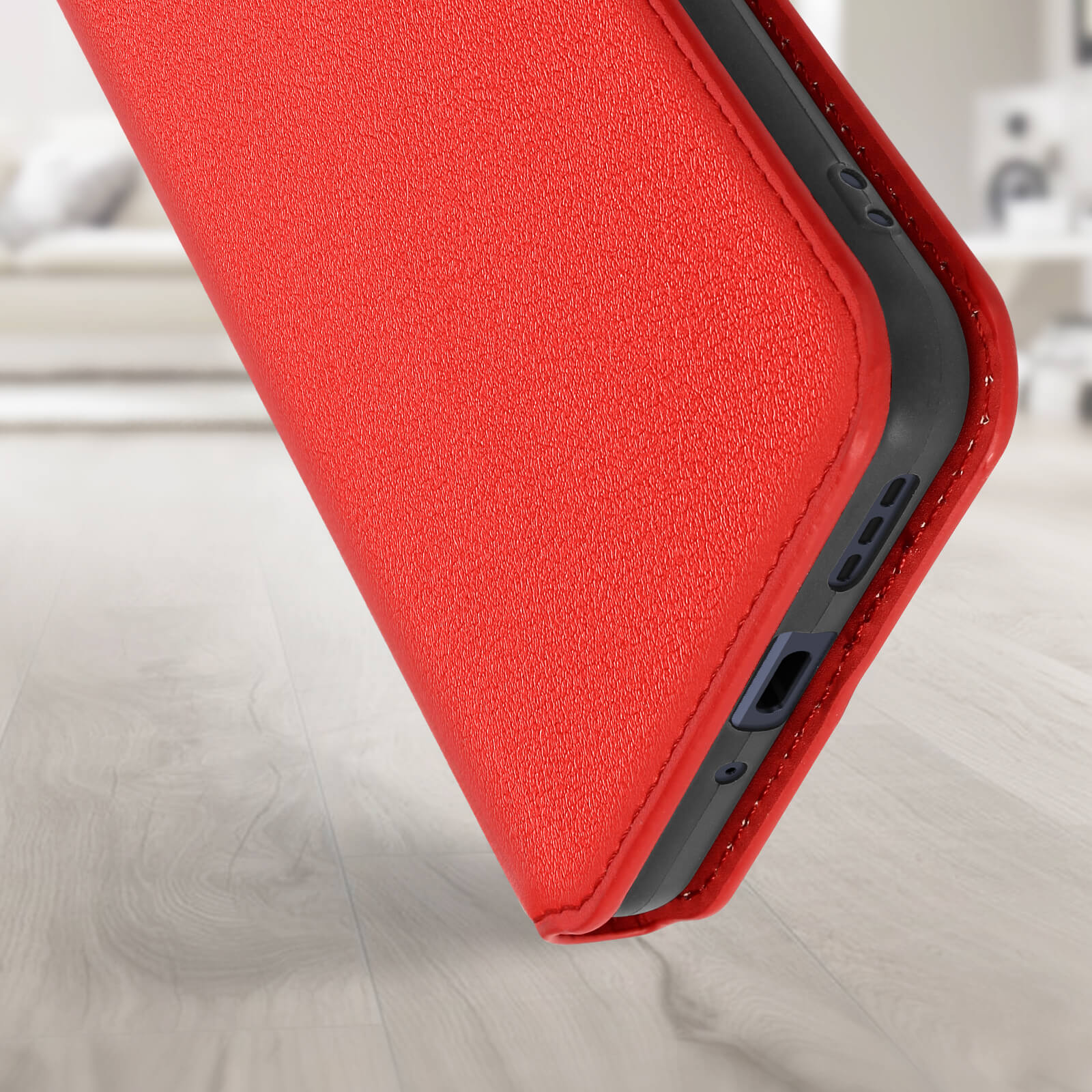 Custodia rossa per telefono su pavimento in legno. La custodia copre i bordi del telefono.