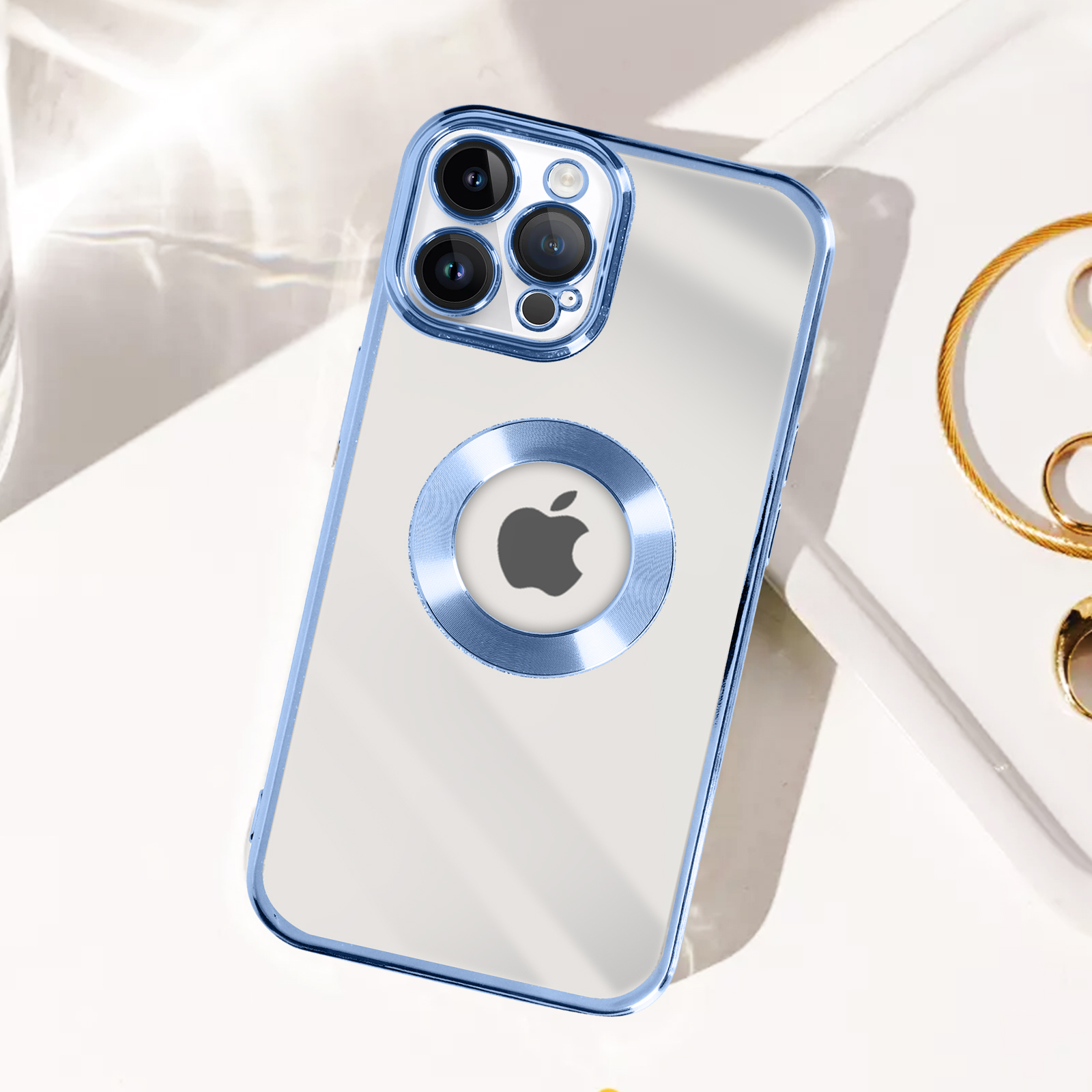 Custodia trasparente per iPhone con bordo blu e anello con logo Apple argentato, su una superficie bianca.