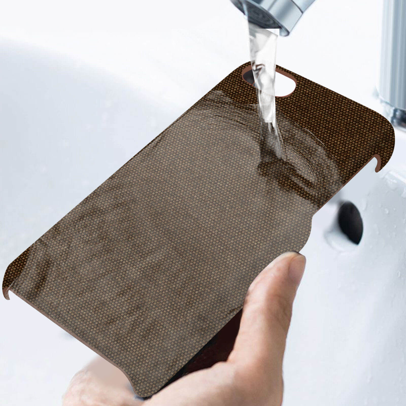 Una custodia per telefono viene lavata sotto l'acqua corrente in un lavandino.