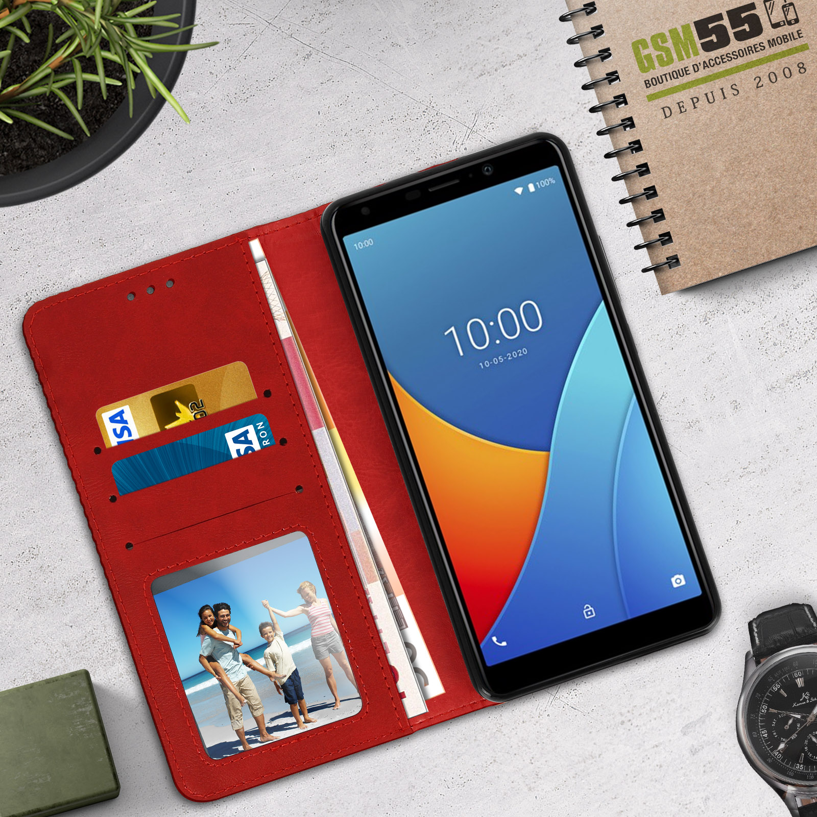 Una funda de teléfono tipo cartera roja está abierta, con un teléfono que muestra la hora, tarjetas y una foto familiar.