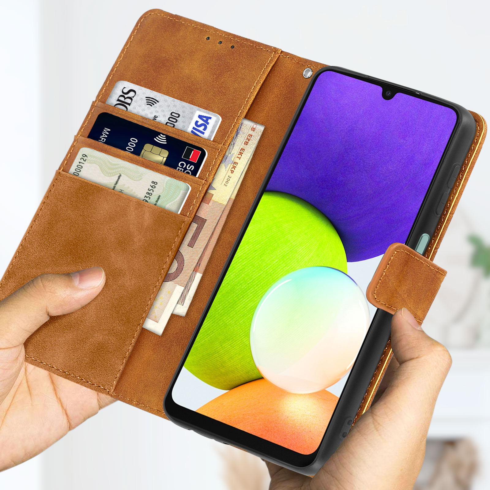 Funda de teléfono marrón abierta con tarjetas y teléfono dentro. Manos visibles.