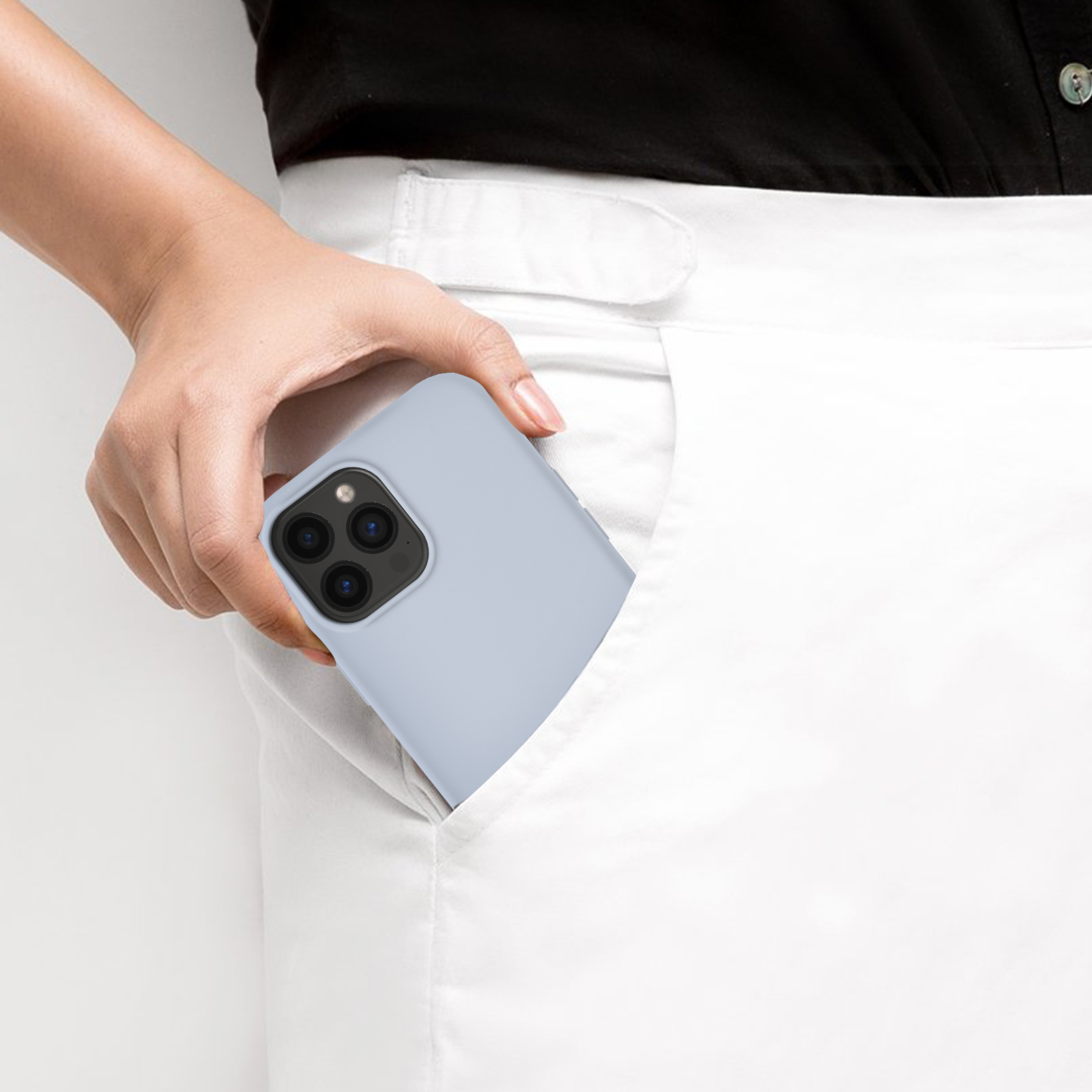 La mano di una persona nella tasca dei pantaloni bianchi con una custodia per telefono azzurra all'interno.