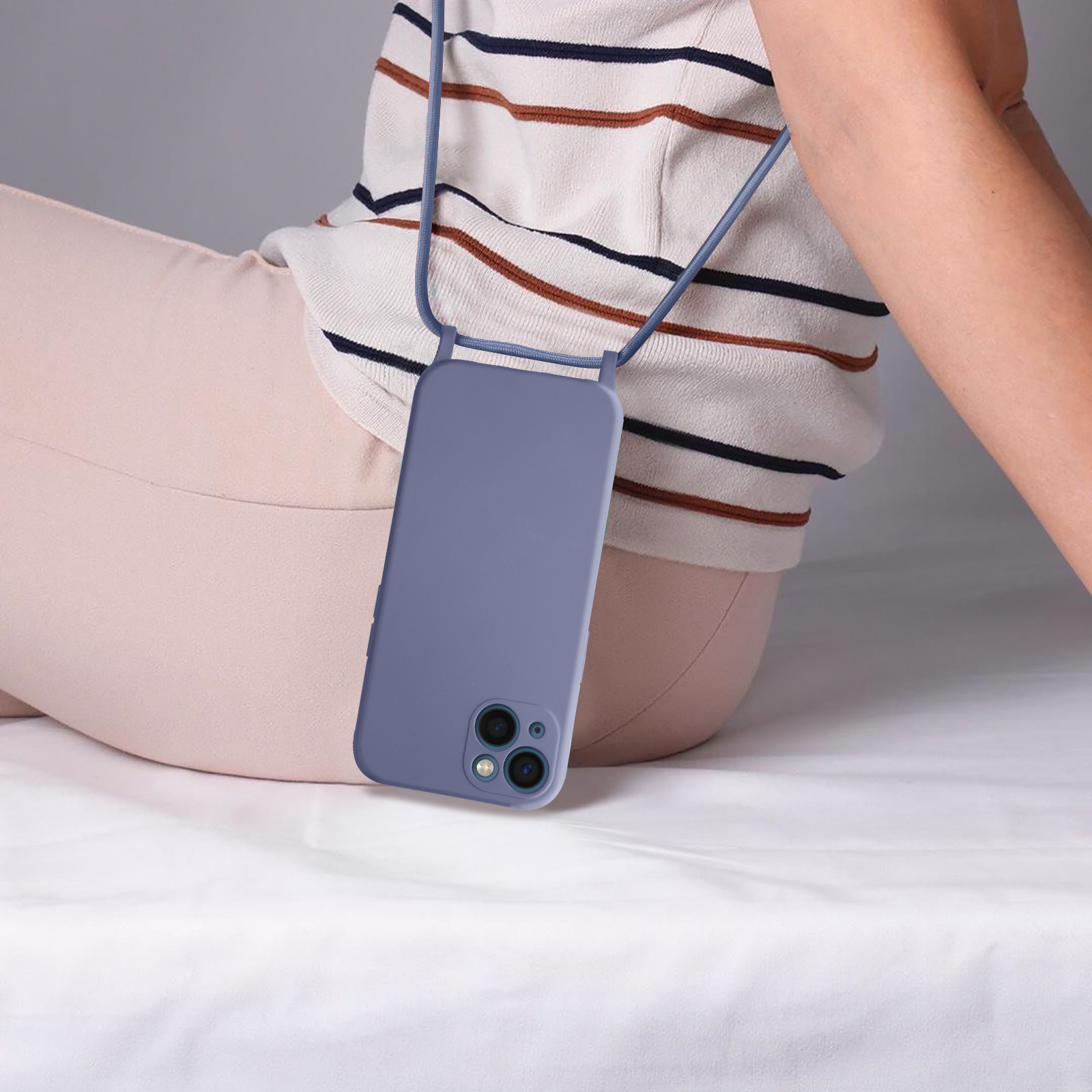 Una custodia per telefono viola con un cordino intorno al collo di una persona, su sfondo bianco.