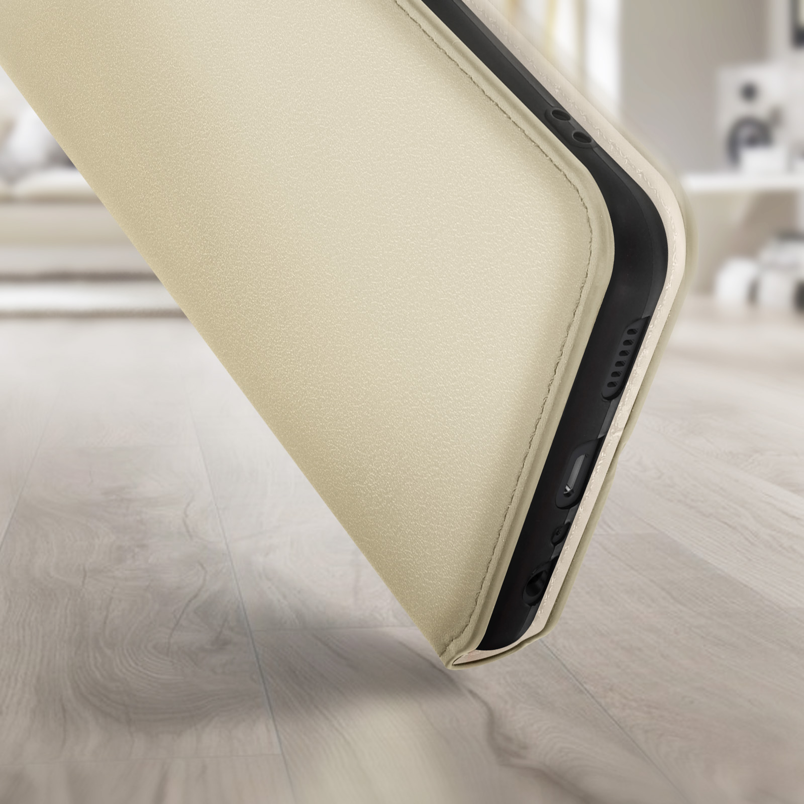 Primo piano di una custodia beige, che mostra il lato con i pulsanti. Sfondo sfocato.