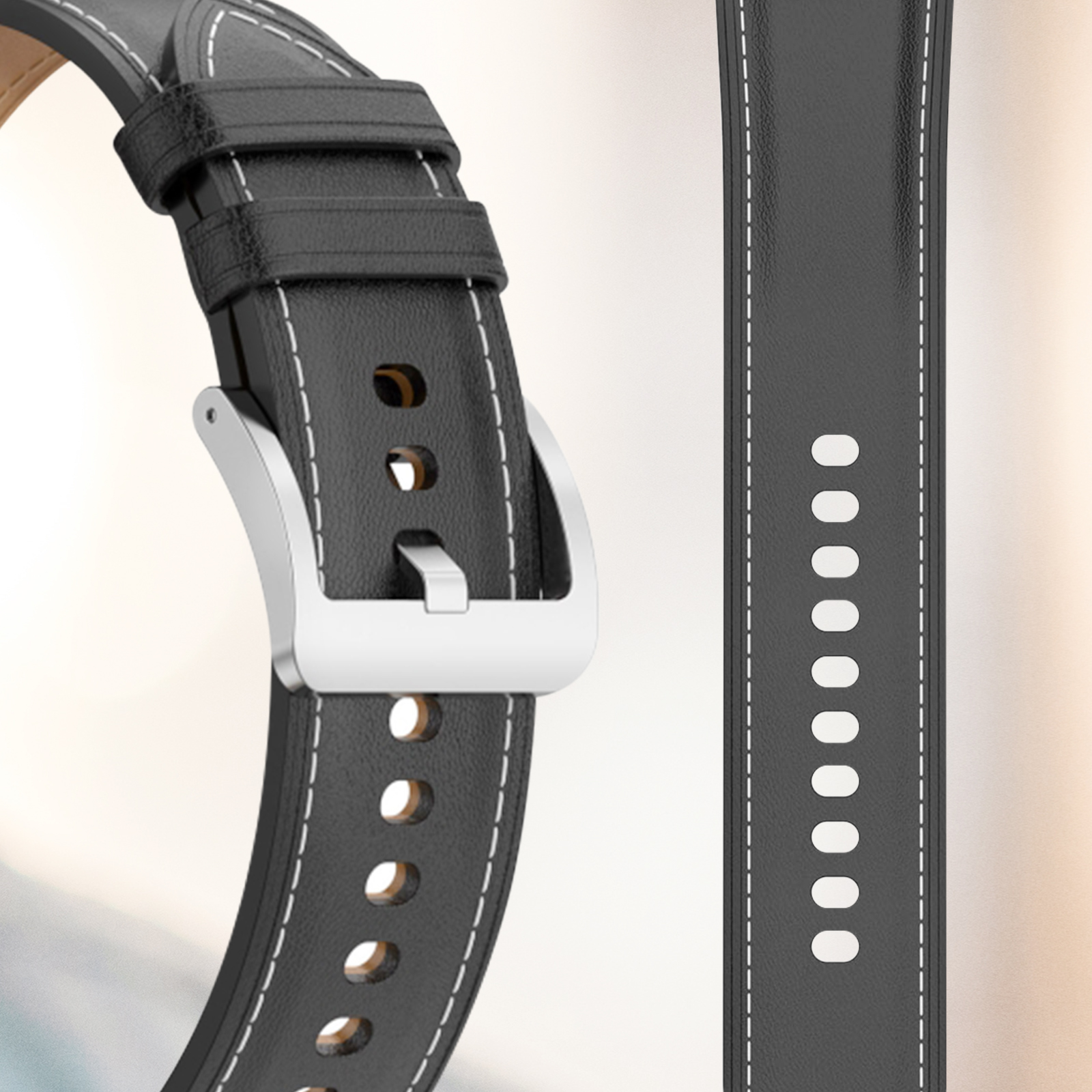 Primer plano de correa de reloj de cuero negro con costuras blancas y hebilla plateada.