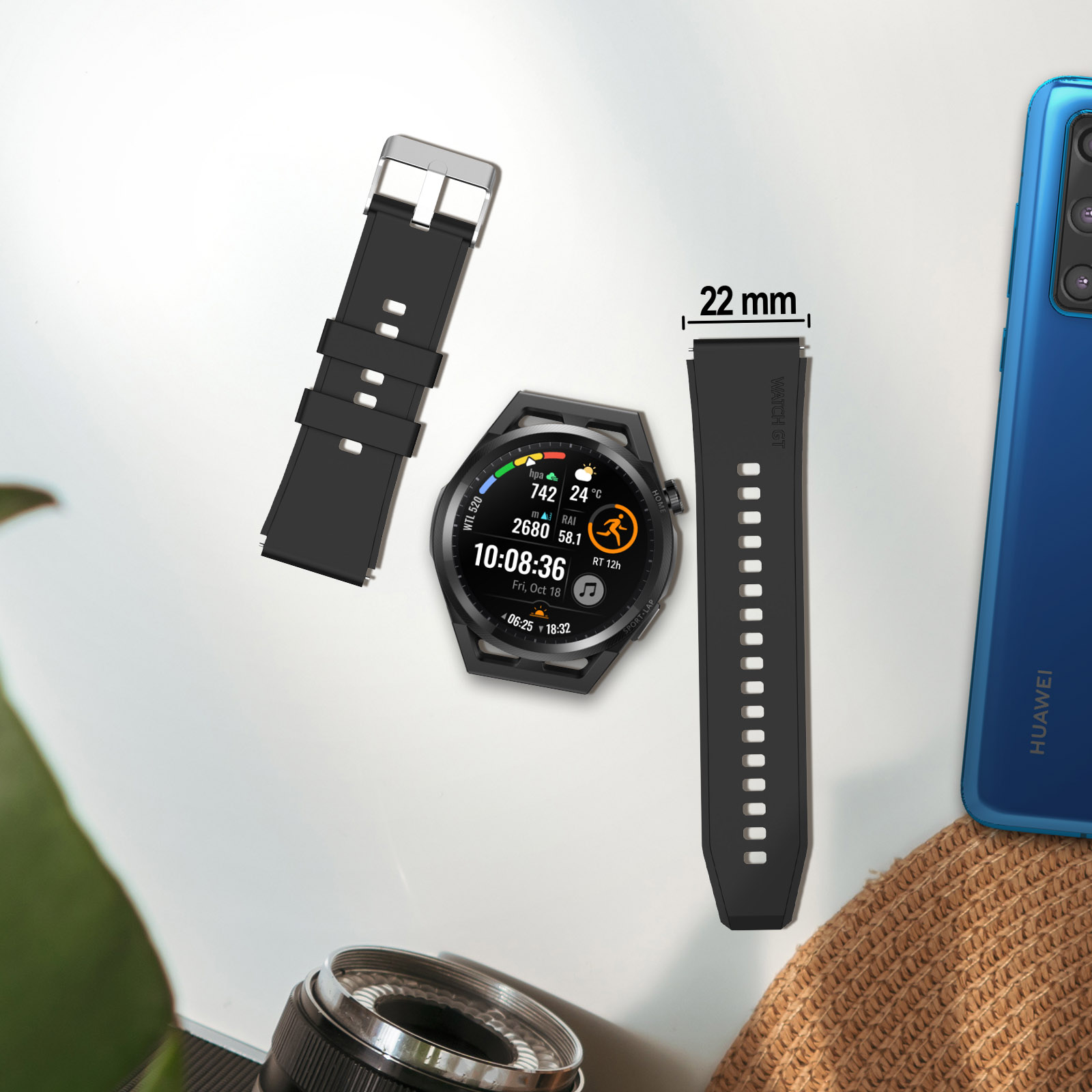 Reloj, correa de reloj y teléfono dispuestos sobre una superficie. Lente de cámara y sombrero.