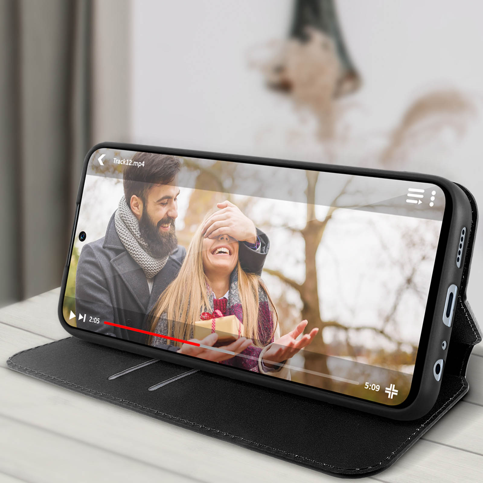 Téléphone affichant une vidéo d'un couple, avec un étui noir.