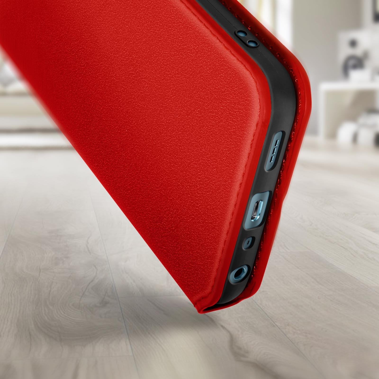 Custodia rossa per telefono. La custodia è aperta, mostrando porte e pulsanti. Pavimento in legno sullo sfondo.