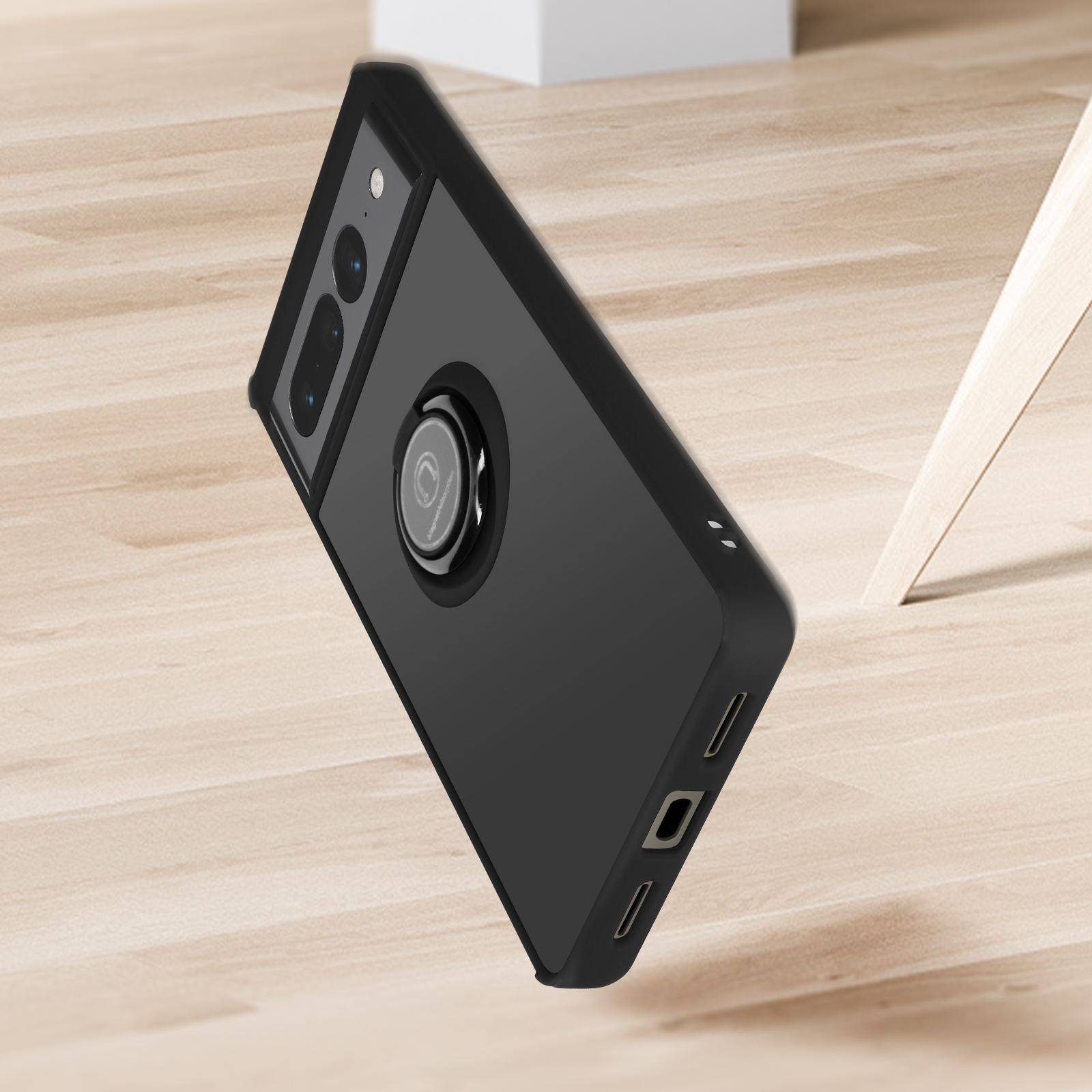 Zwarte telefoonhoes met een ringhouder, rustend op een houten vloer. De hoes is schuin.