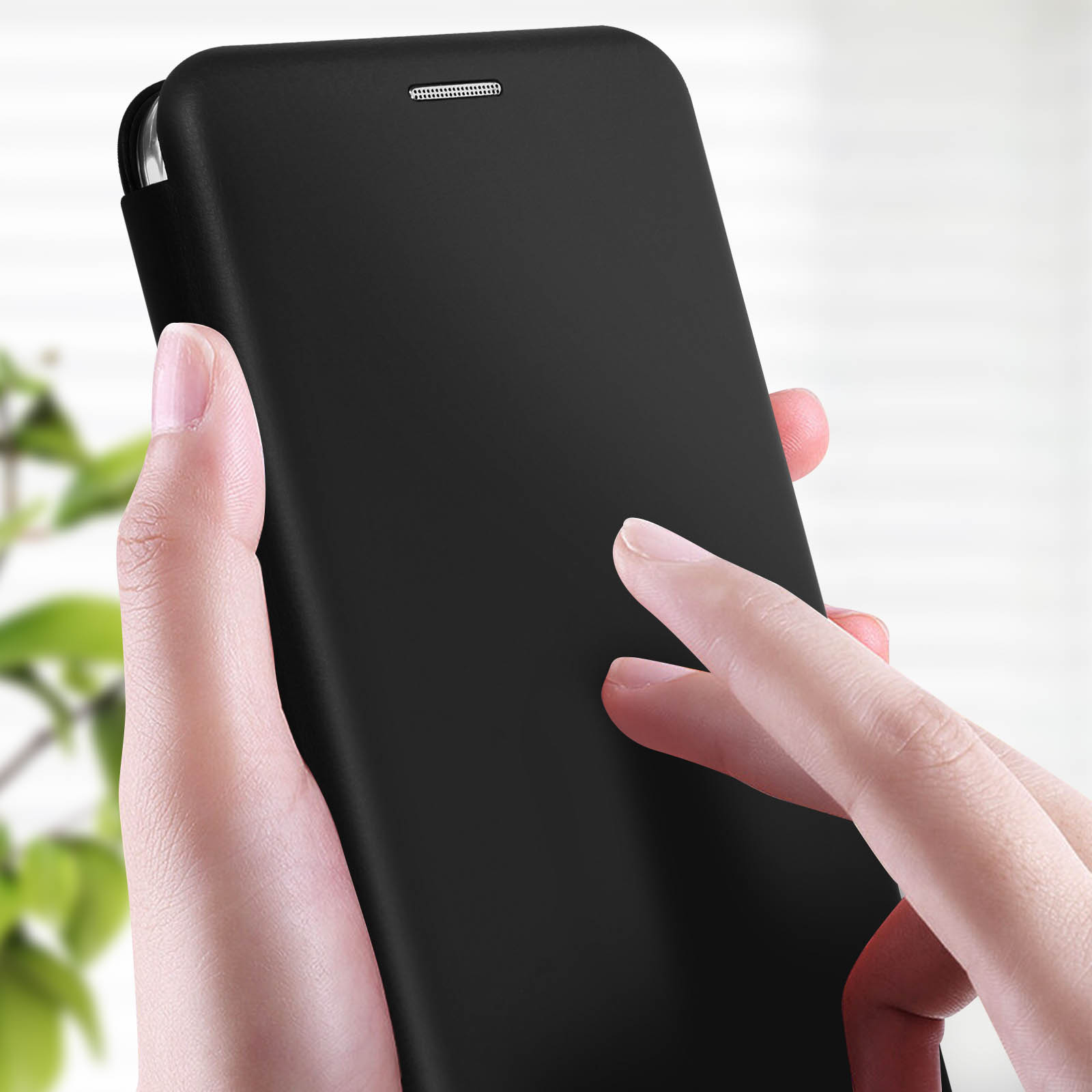 Eine Hand, die eine schwarze Handyhülle hält, mit einem Finger, der den Bildschirm berührt.