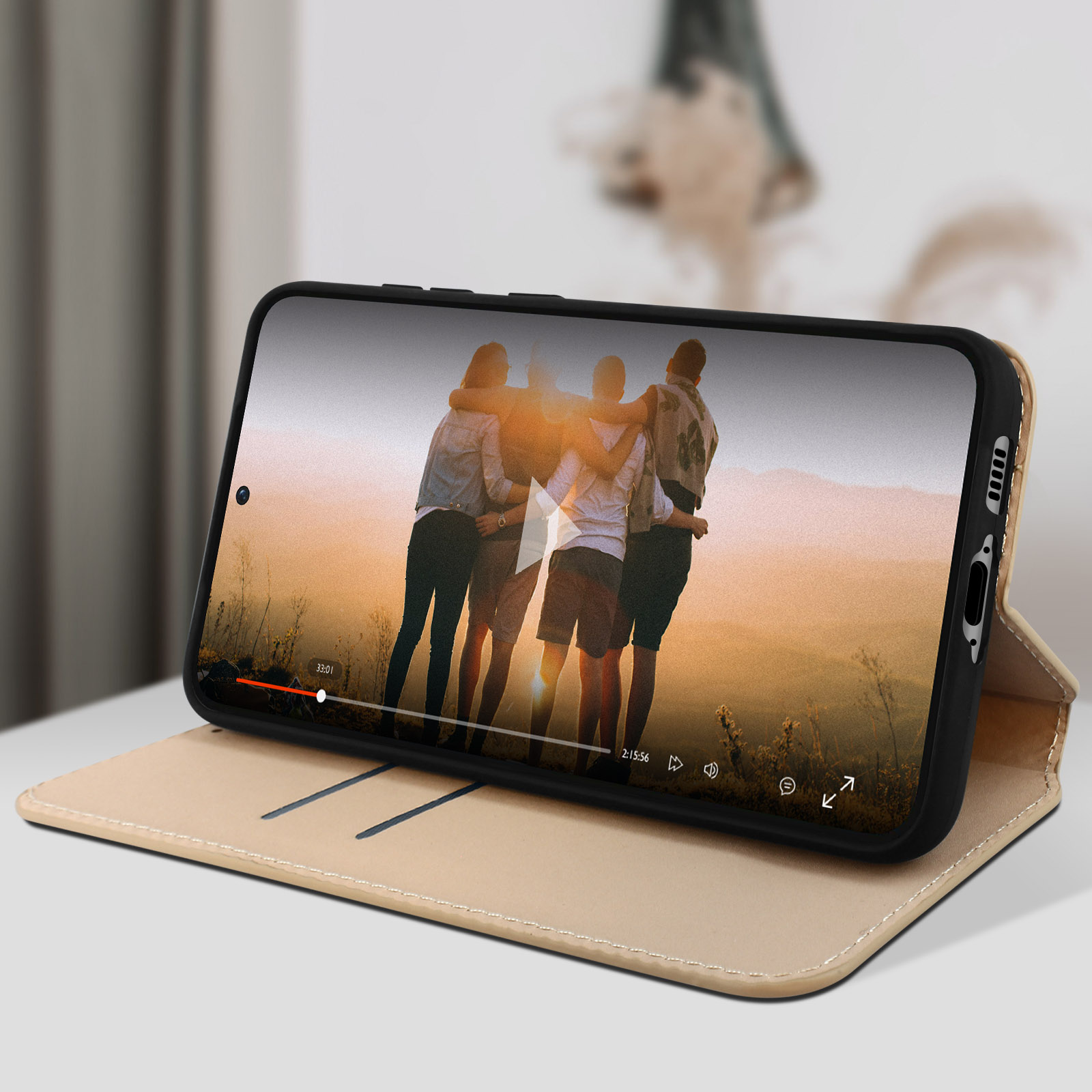 Telefono che riproduce video su una custodia beige. Un gruppo di persone è sullo schermo.