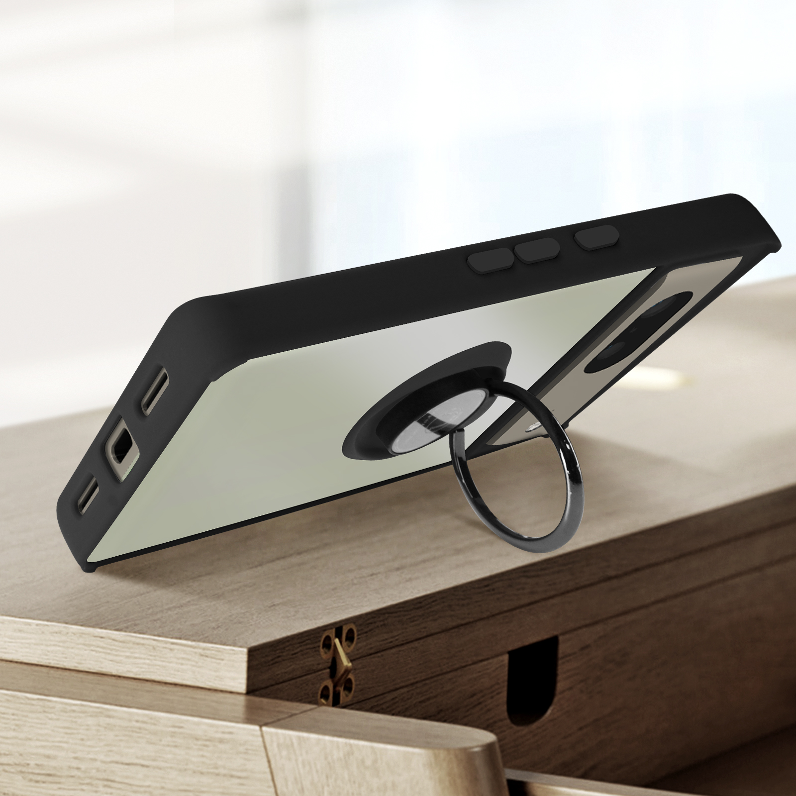 Telefono in custodia nera con anello di supporto su un tavolo di legno. L'anello di supporto è argentato.