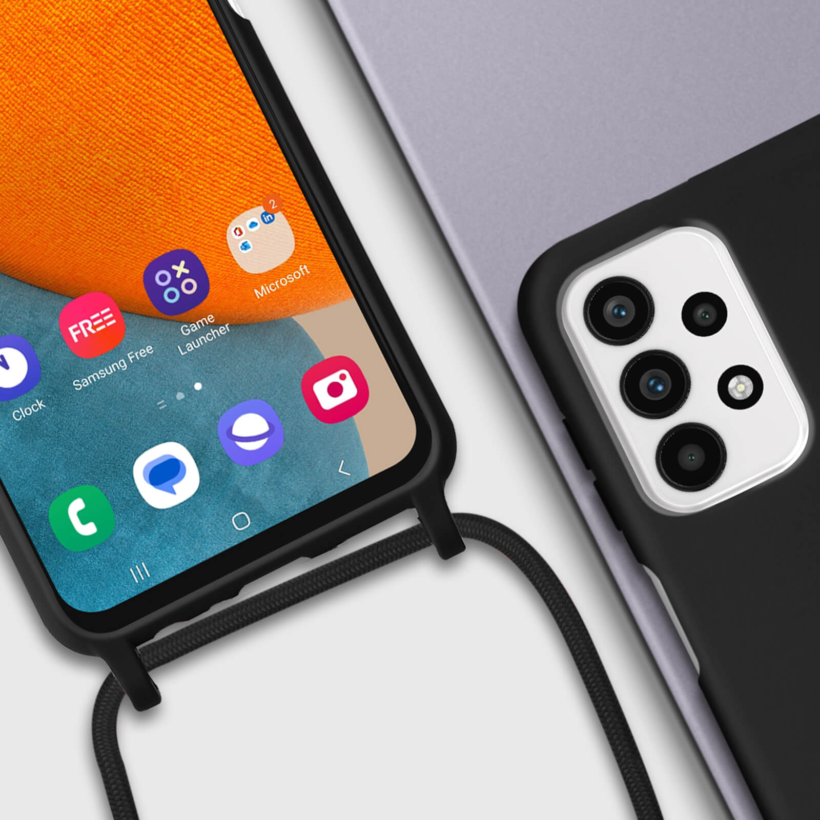 Écran de téléphone affichant des applications. Téléphone avec coque noire, attaché avec une sangle noire.
